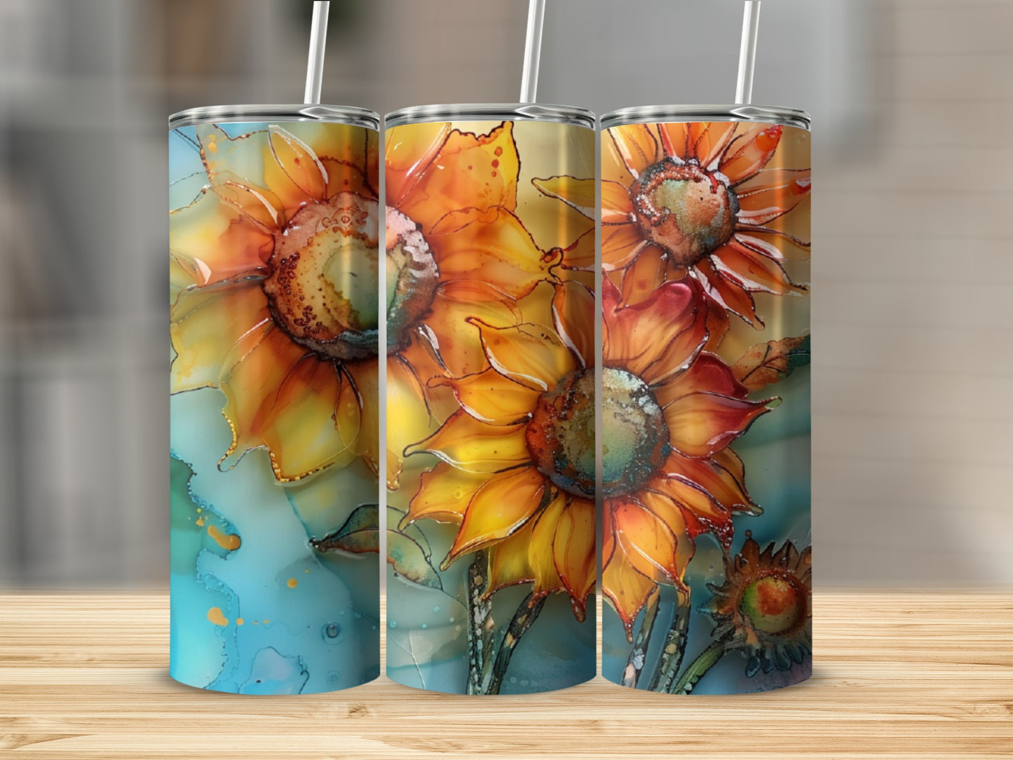 Three tumblers with watercolor sunflower designs on a wooden surface.
