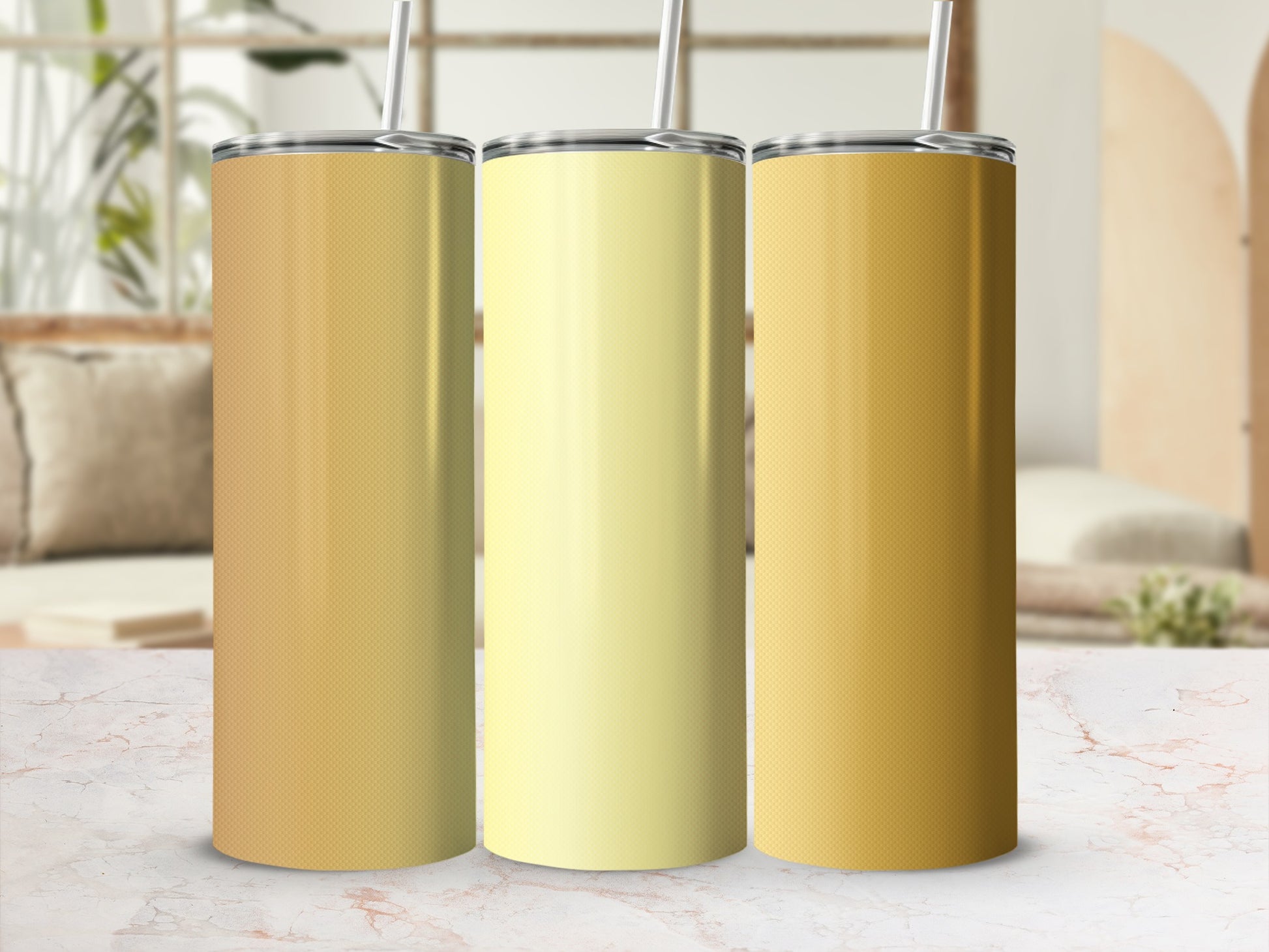 Three insulated tumblers with subtle ombre designs sit on a marbled surface.