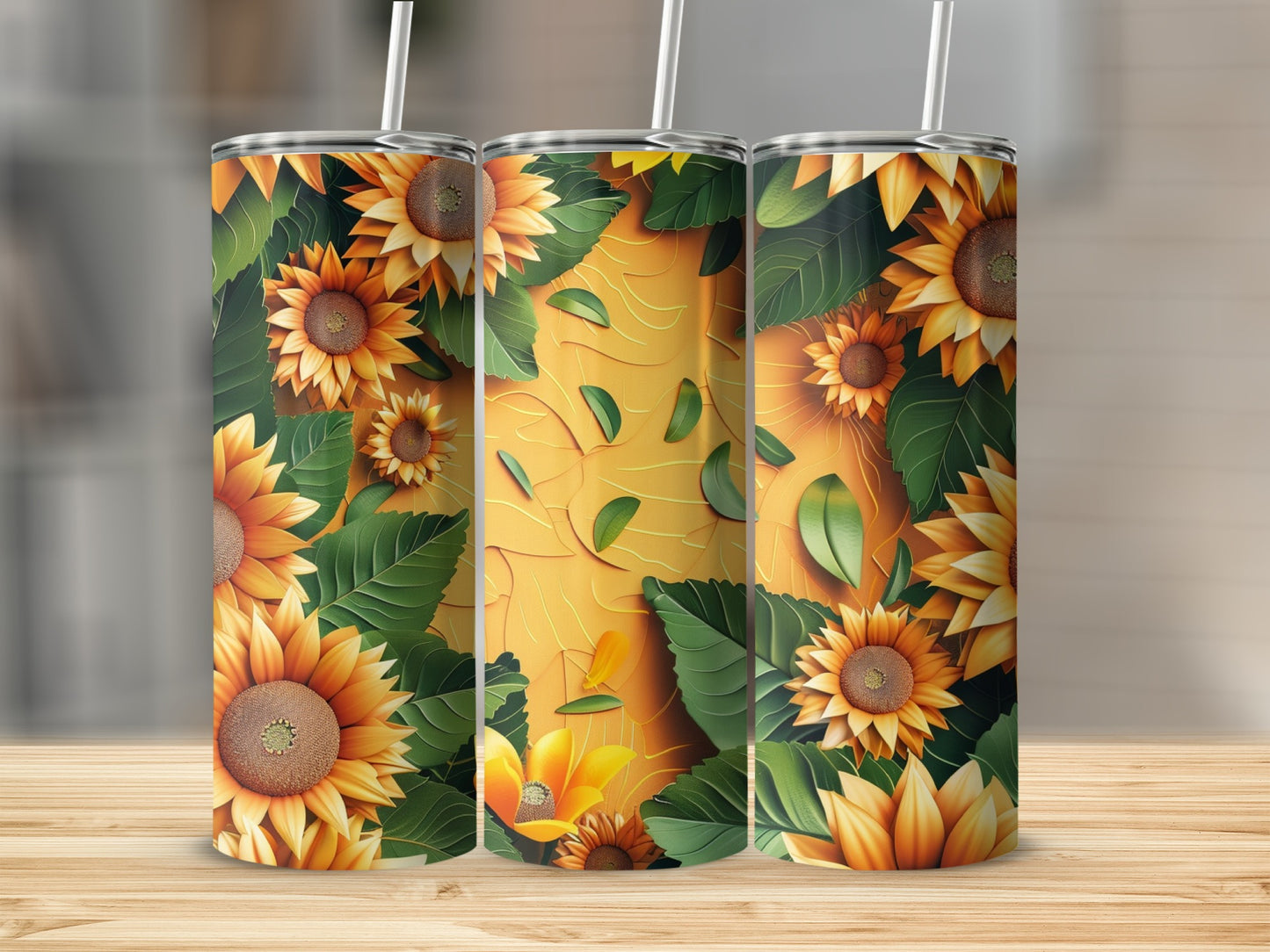 Three tumblers with sunflower and leaf pattern on a wooden surface.