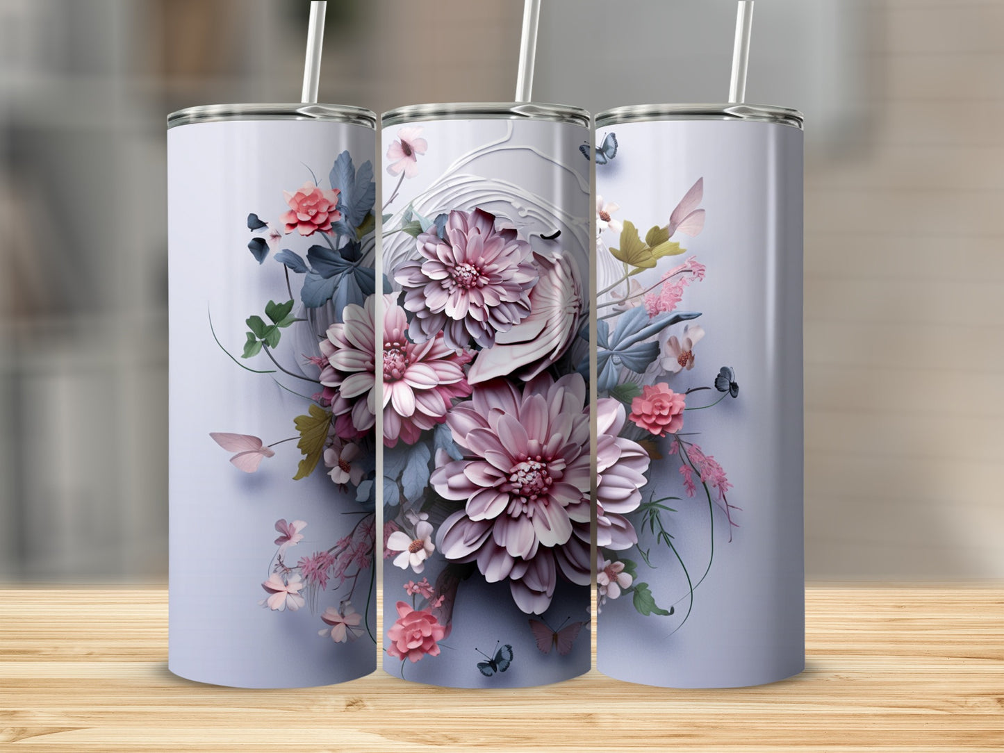 Three tumblers with floral designs on a wooden surface.