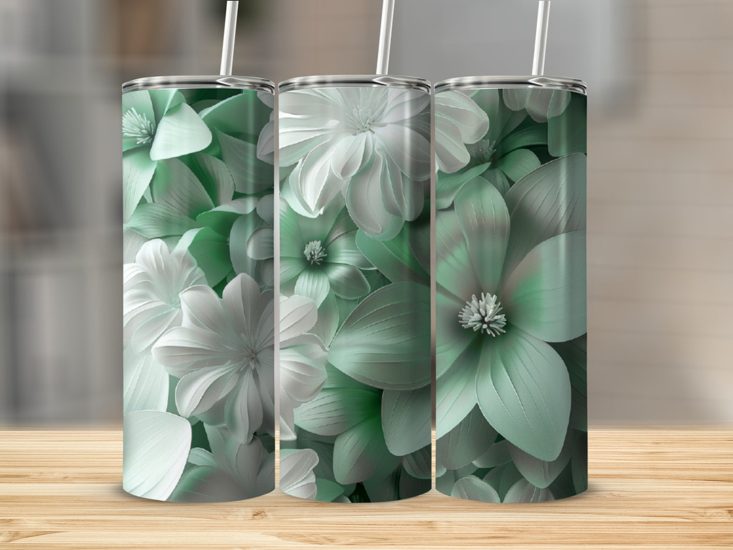 Three tumblers with a muted green floral design on a wooden surface.