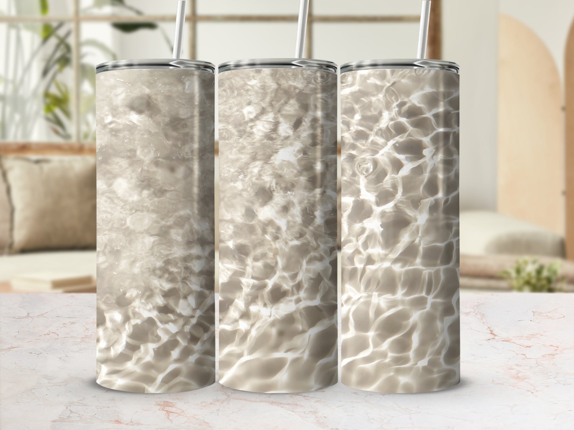 Three tumblers with a water ripple pattern against a blurred living room background.