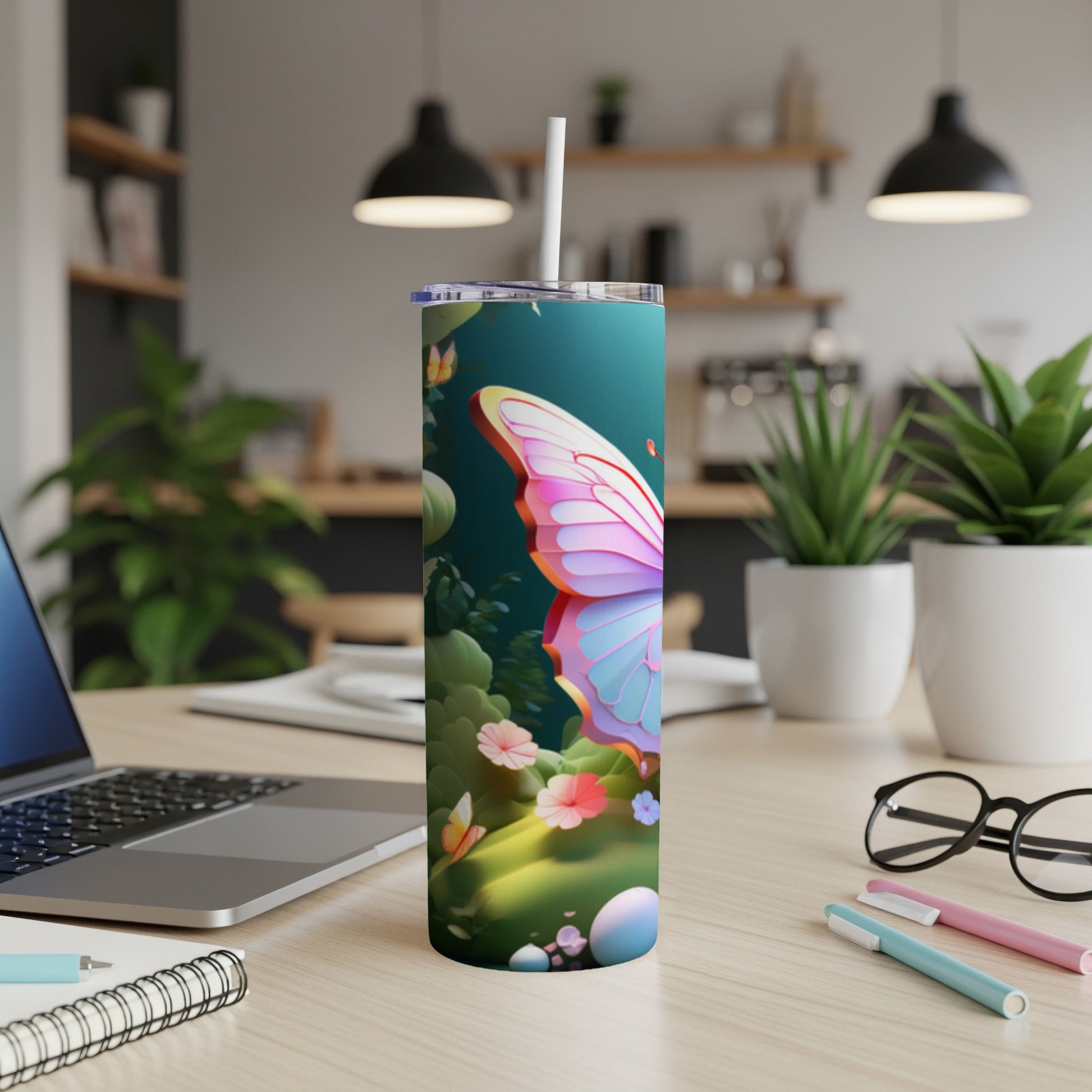 Tumbler with a butterfly and floral design, on a desk.