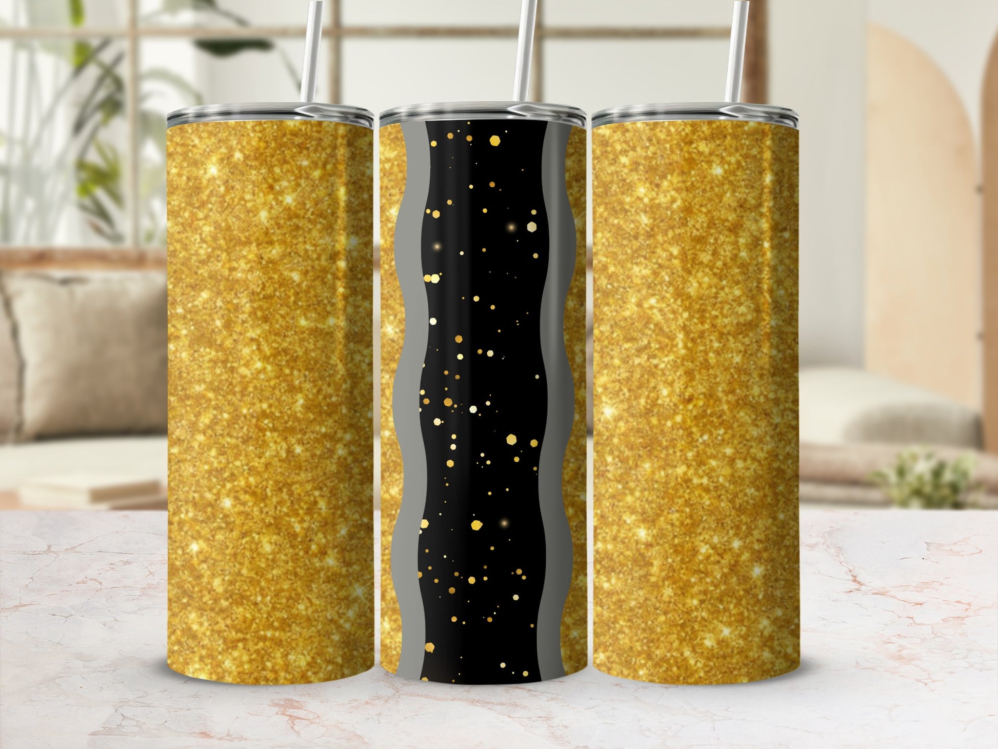 Three glitter tumblers on a marble surface, two gold glitter, one black with gold specks.