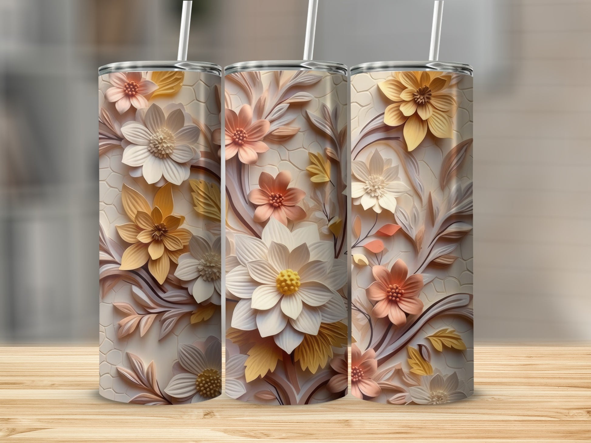 Three tall tumblers with intricate floral designs and straws.
