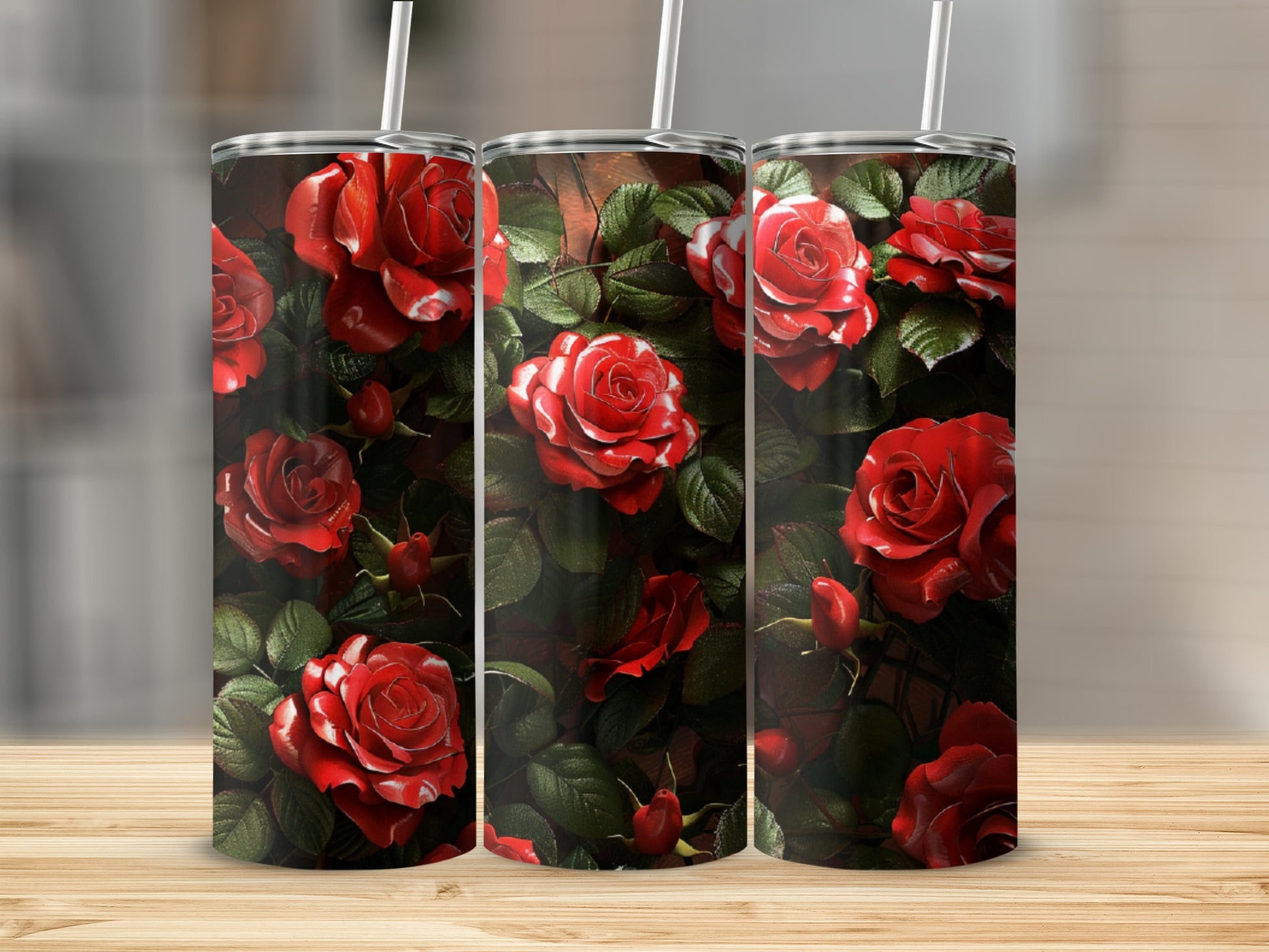 Three tumblers with a red rose floral design and straws.
