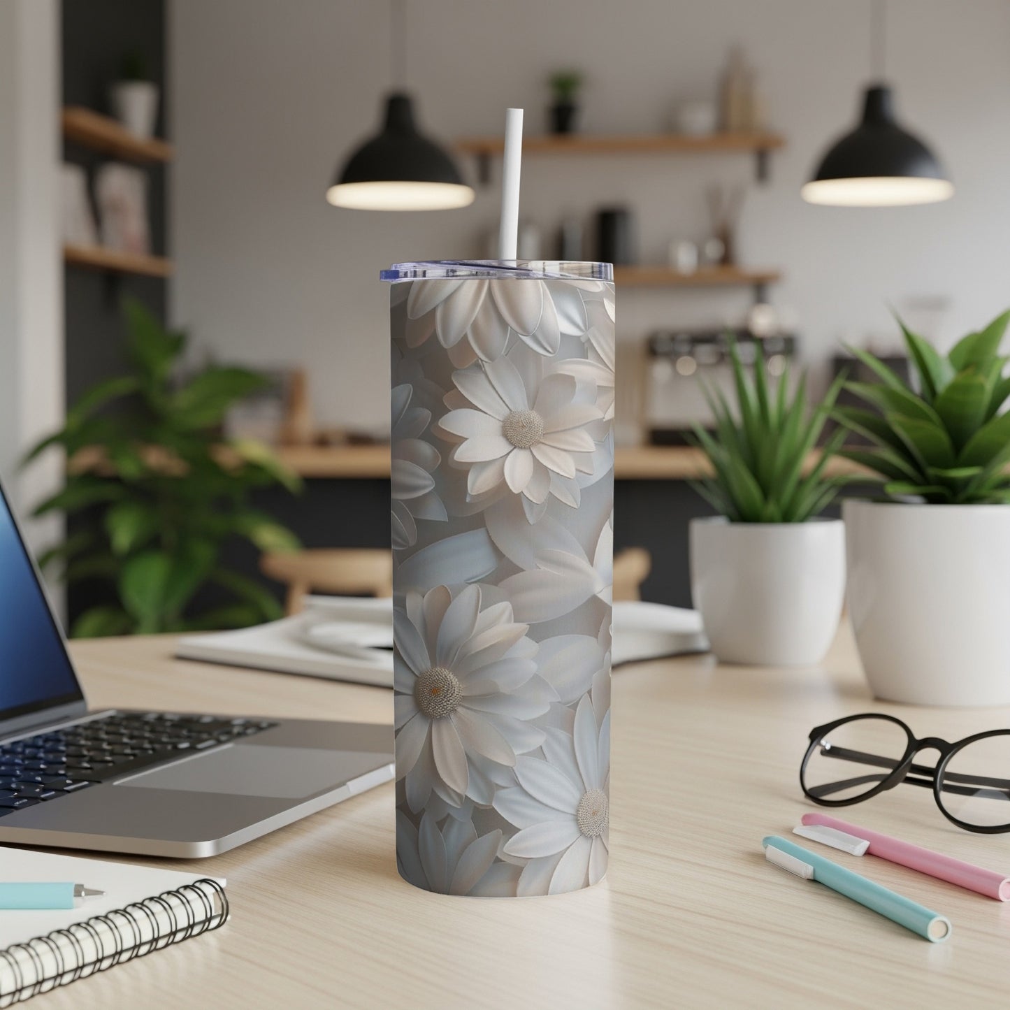 Floral pattern skinny tumbler with straw on a desk.