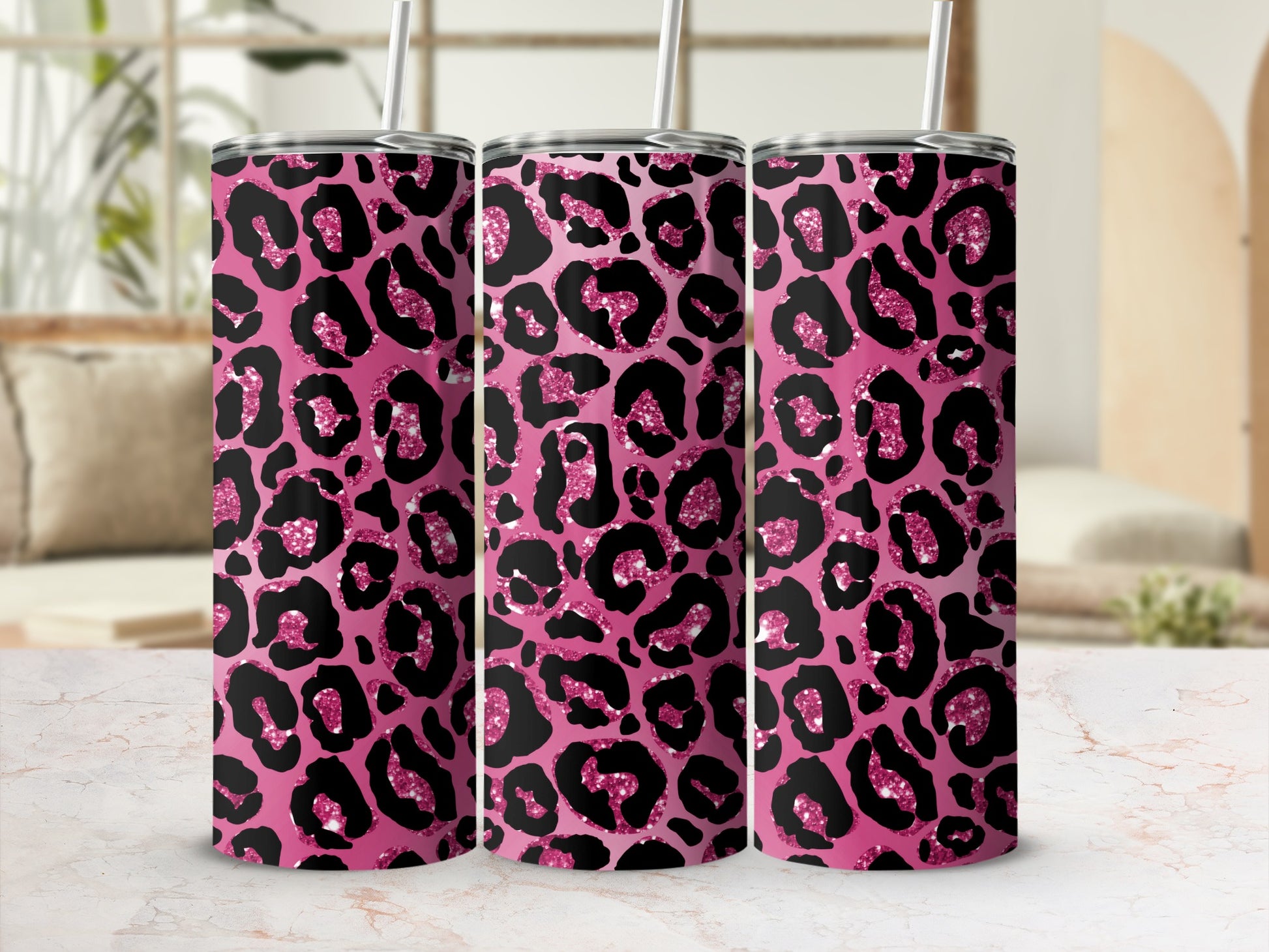 Three pink tumblers with a black and glittery leopard print and white straws.