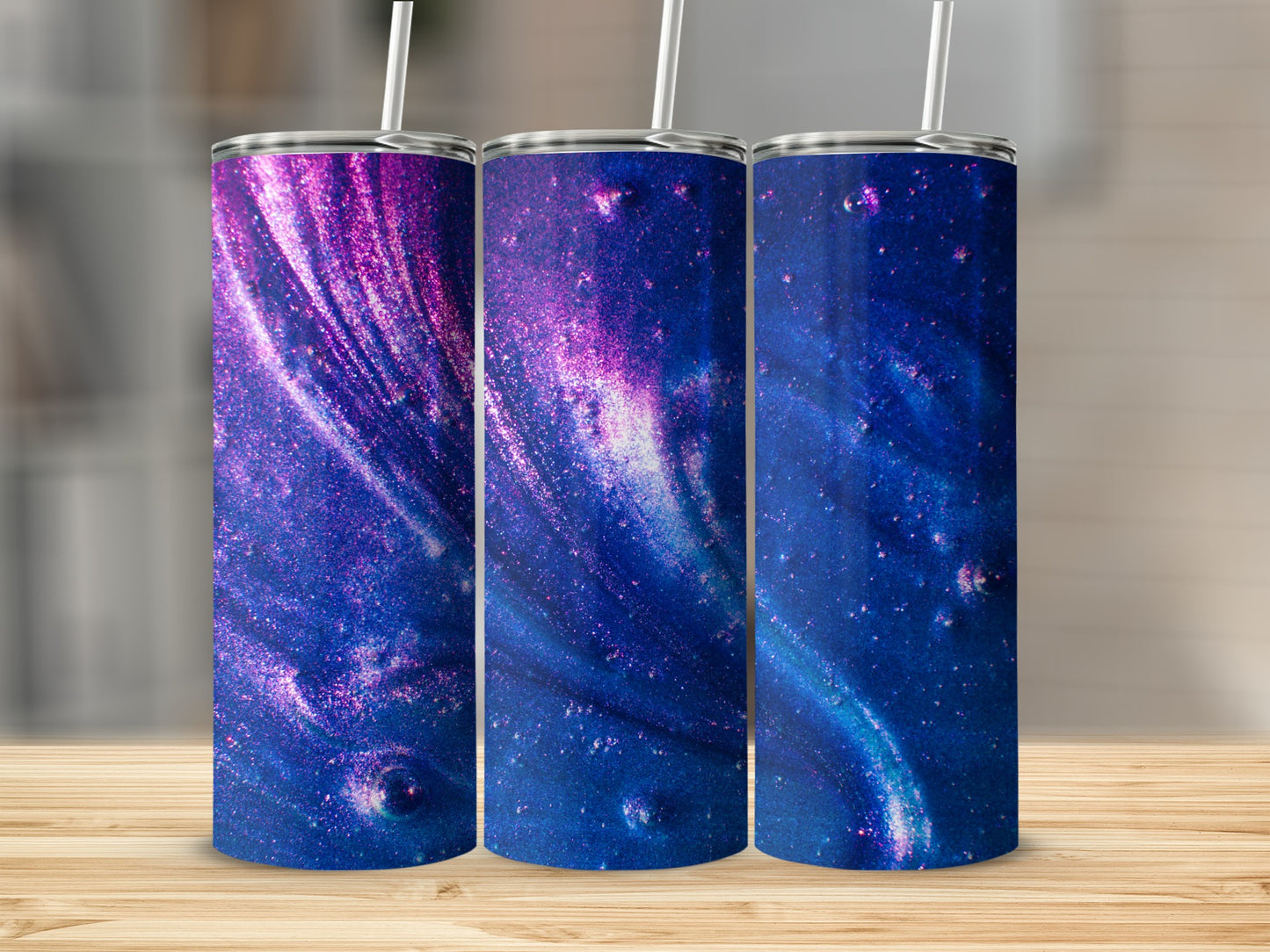 Three tumblers with cosmic purple and blue glitter patterns.