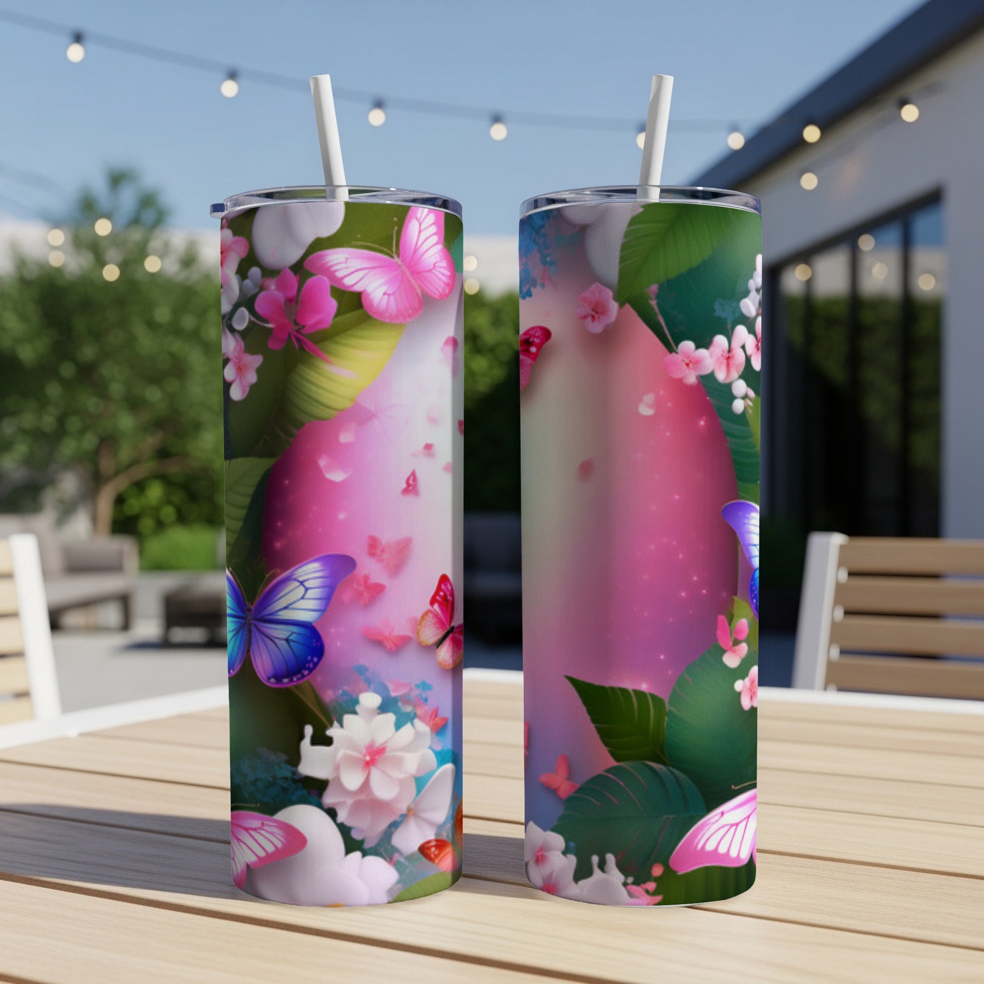 Two tumblers with a vibrant butterfly and floral design, outdoors.