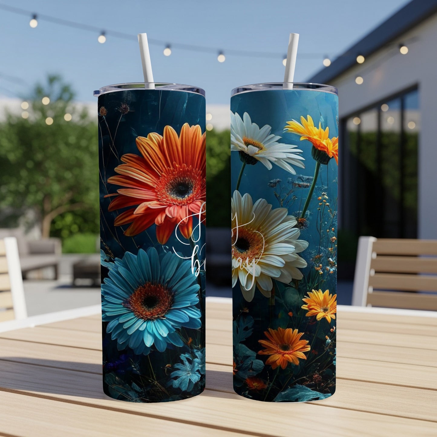 Two tumblers with floral designs, one orange and blue, the other white and yellow flowers.