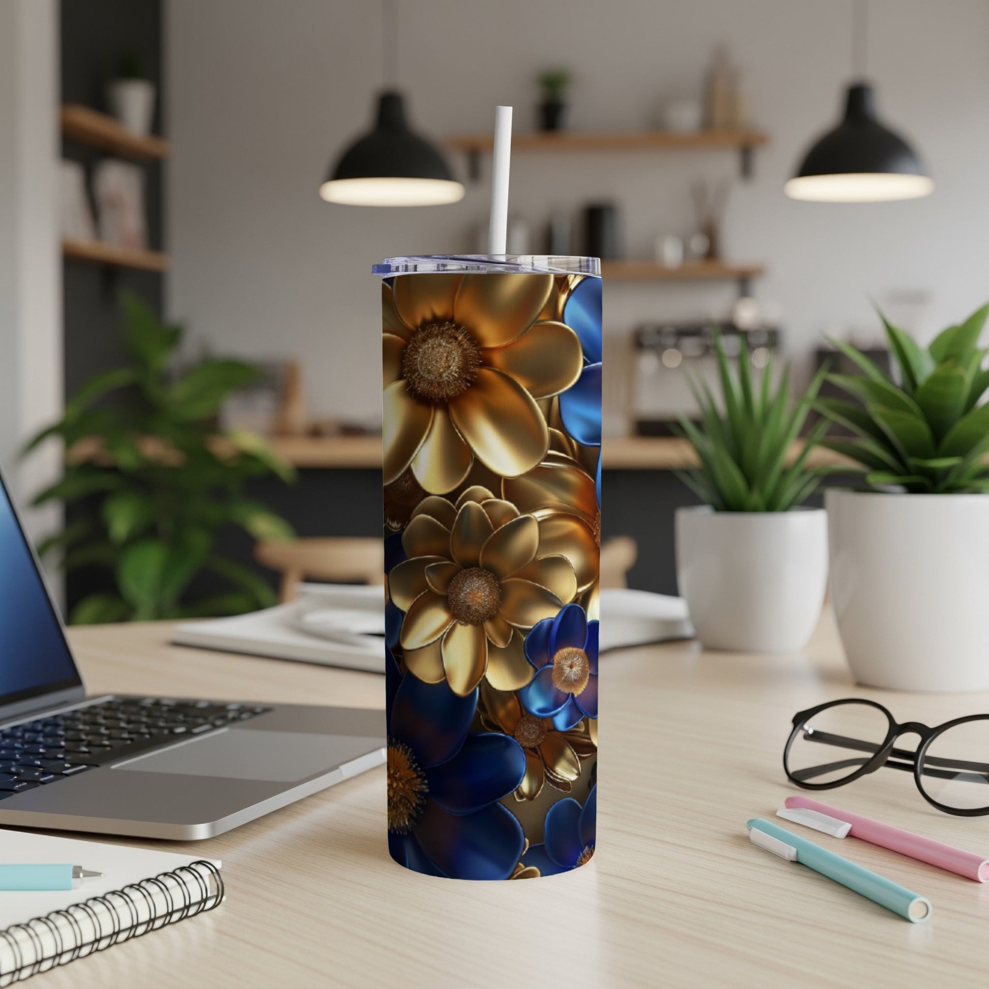 Blue and gold floral print tumbler with straw on a desk.