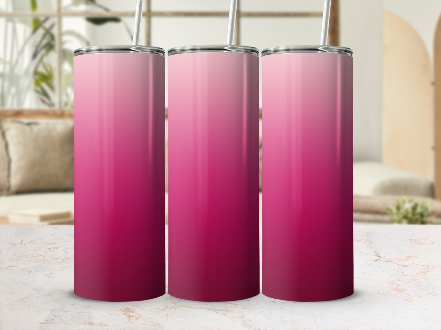 Three tall, pink gradient tumblers with straws on a marble surface.