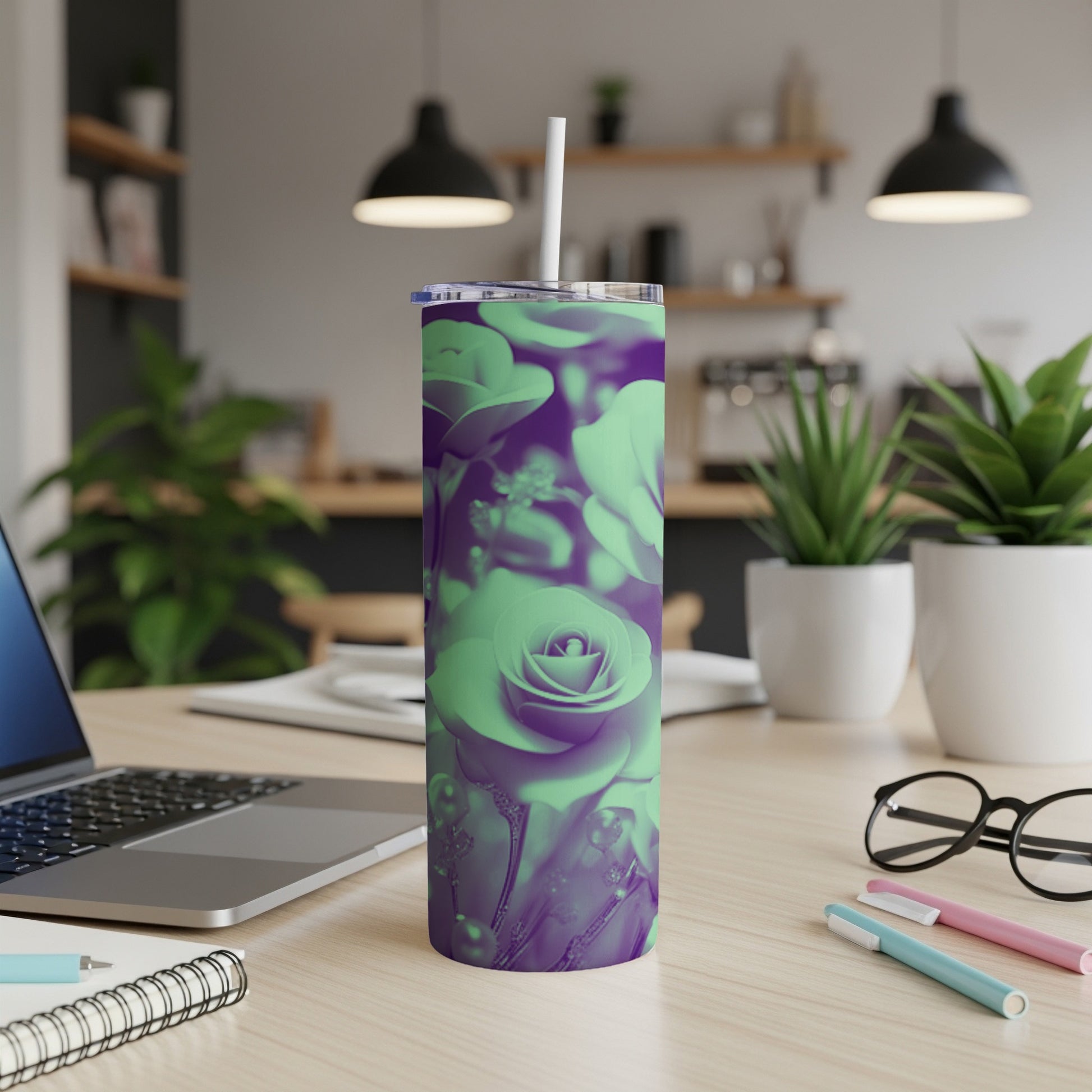 Purple and green rose pattern on a tumbler with a straw on a desk.