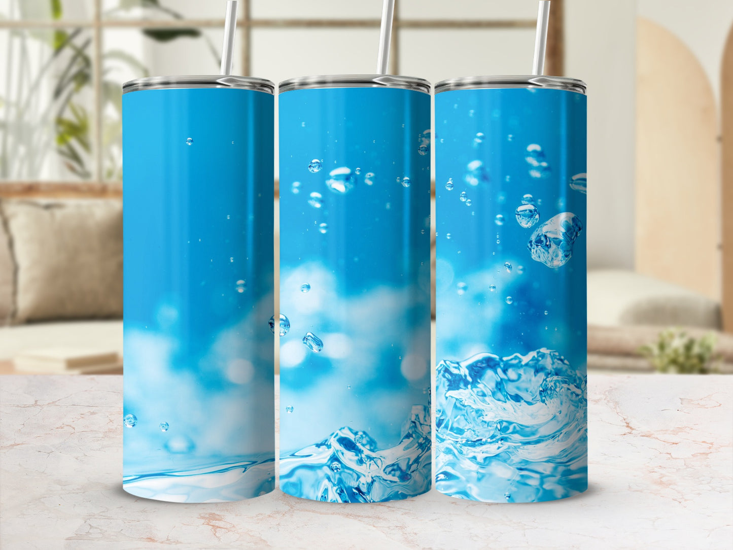 Three blue tumblers with water splashes and bubbles on a marble surface.