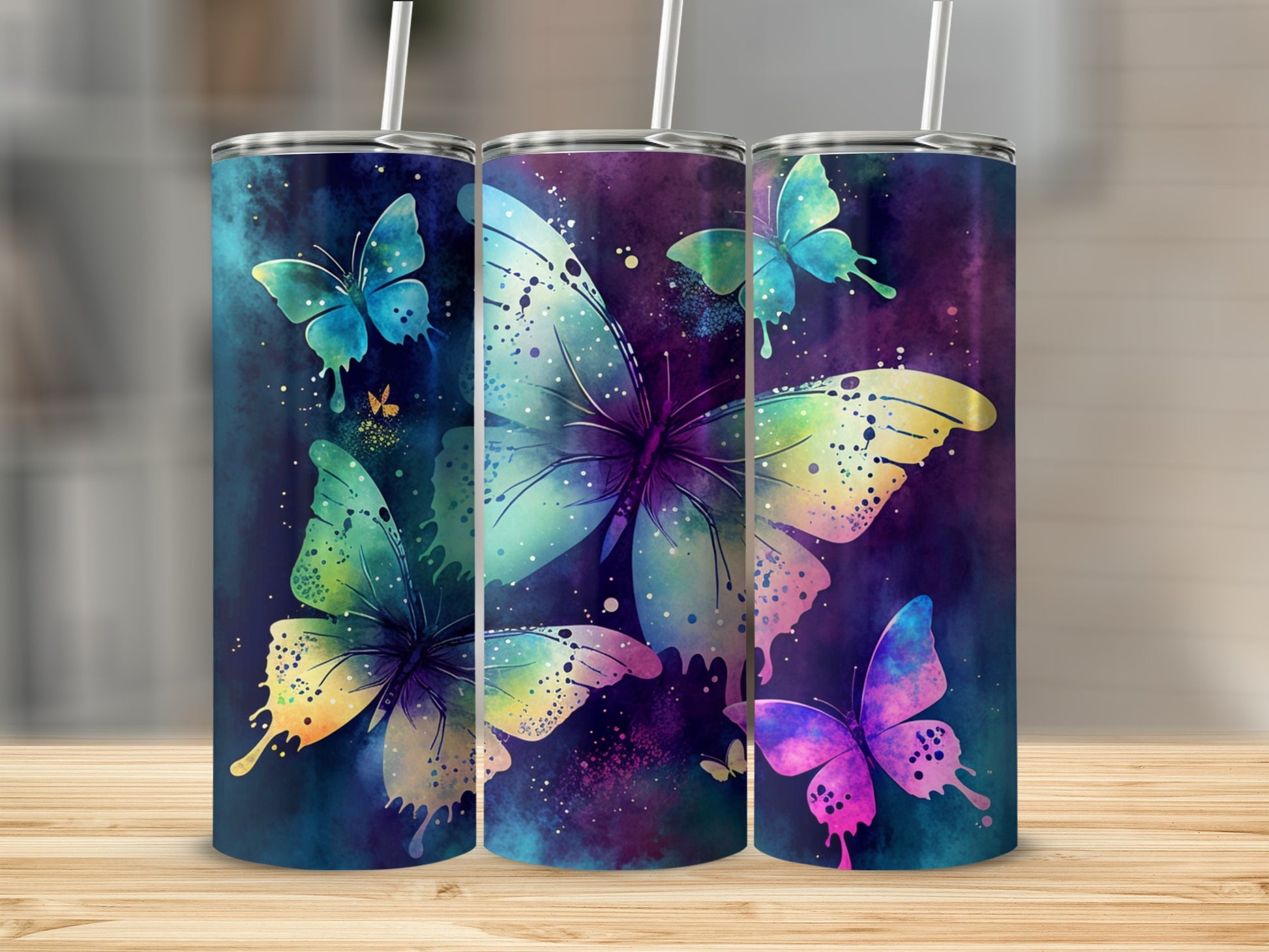Three tumblers with colorful watercolor butterflies and speckles on a dark blue background.