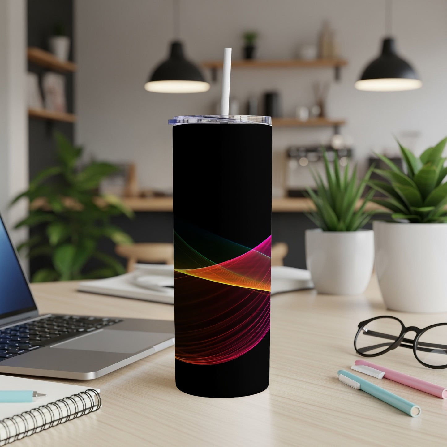 Black tumbler with colorful wavy lines, white straw, on a desk.