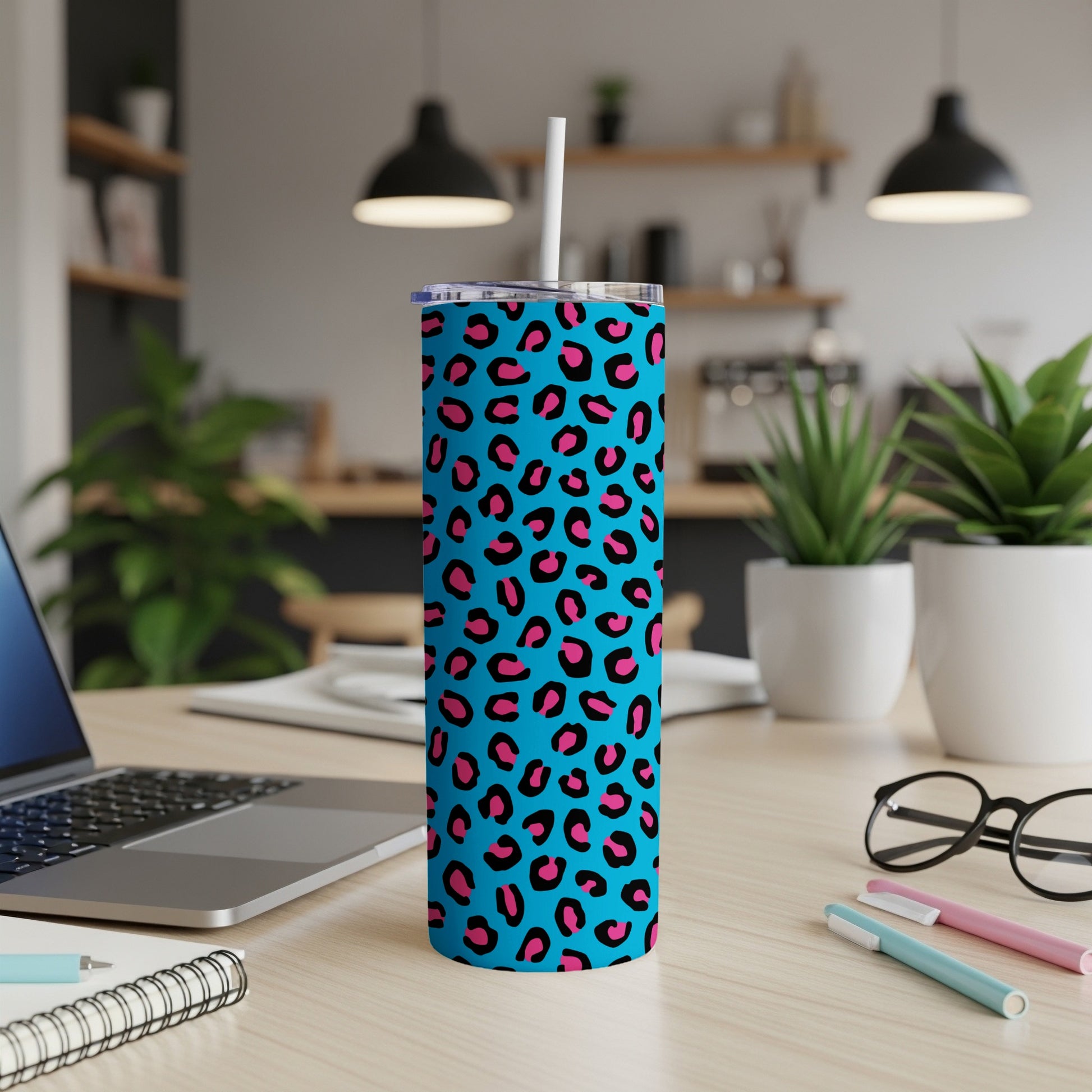 Blue tumbler with pink and black leopard print and white straw.