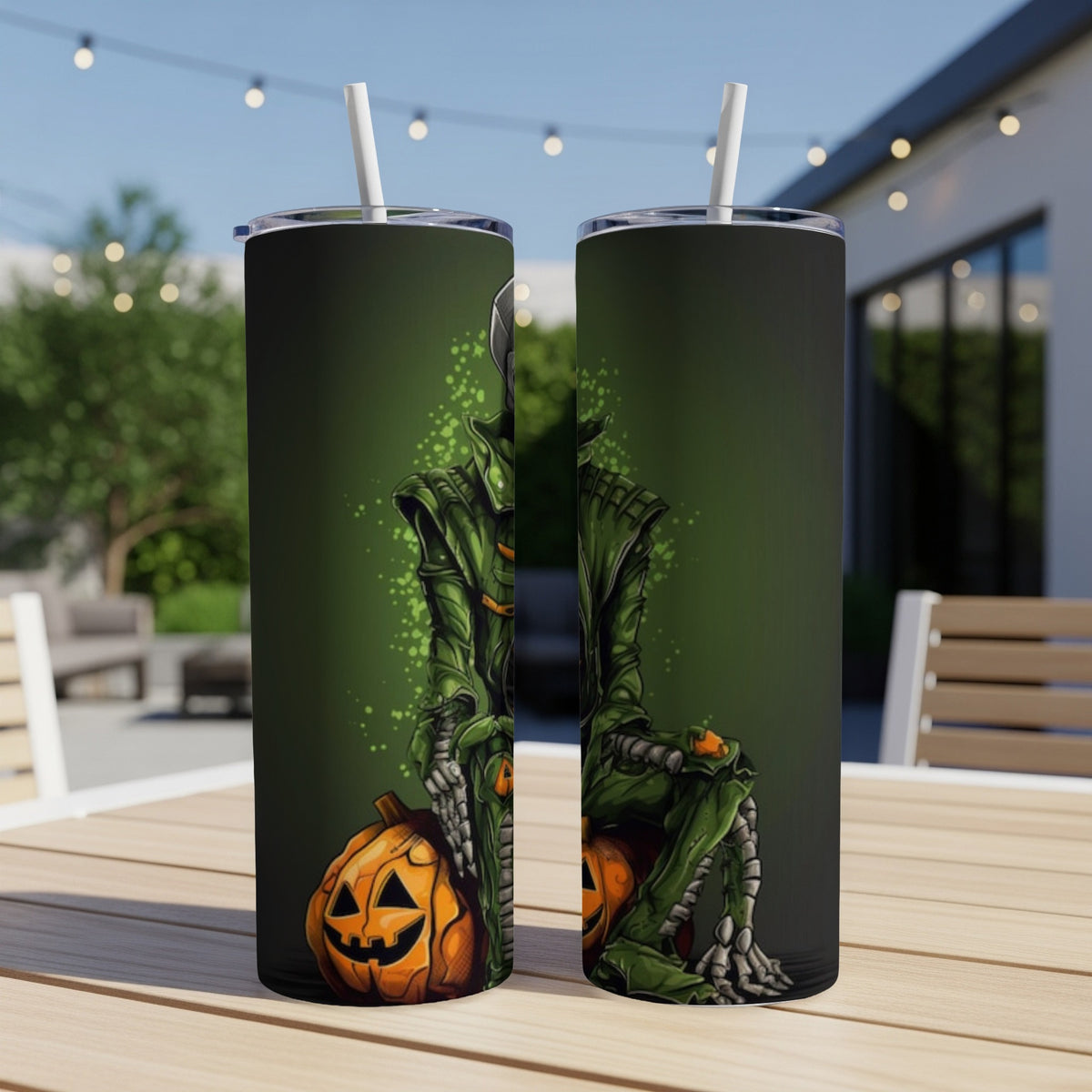 Two tumblers with a green cloaked figure and pumpkins, set outdoors.