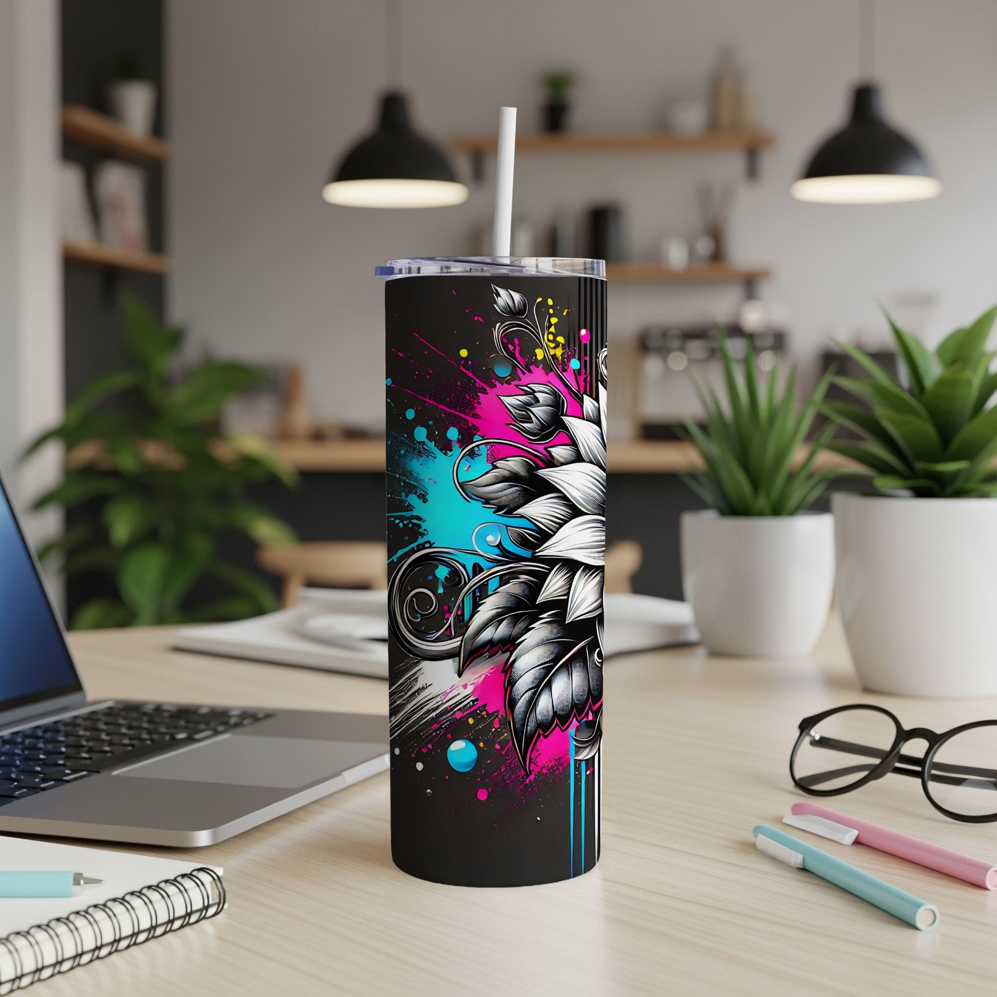 Black tumbler with abstract floral and paint splash design, white straw.