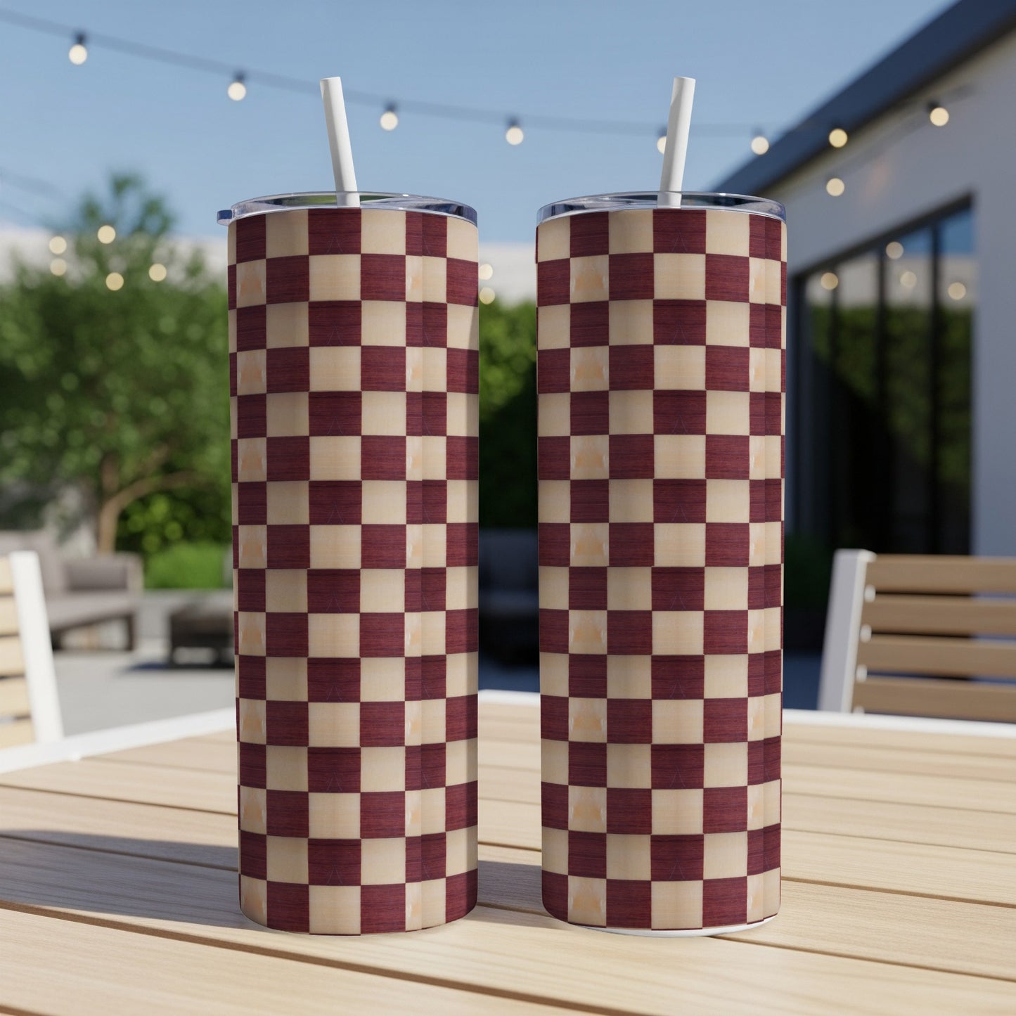 Two tall tumblers with a burgundy and cream checkerboard pattern, on a wooden table.