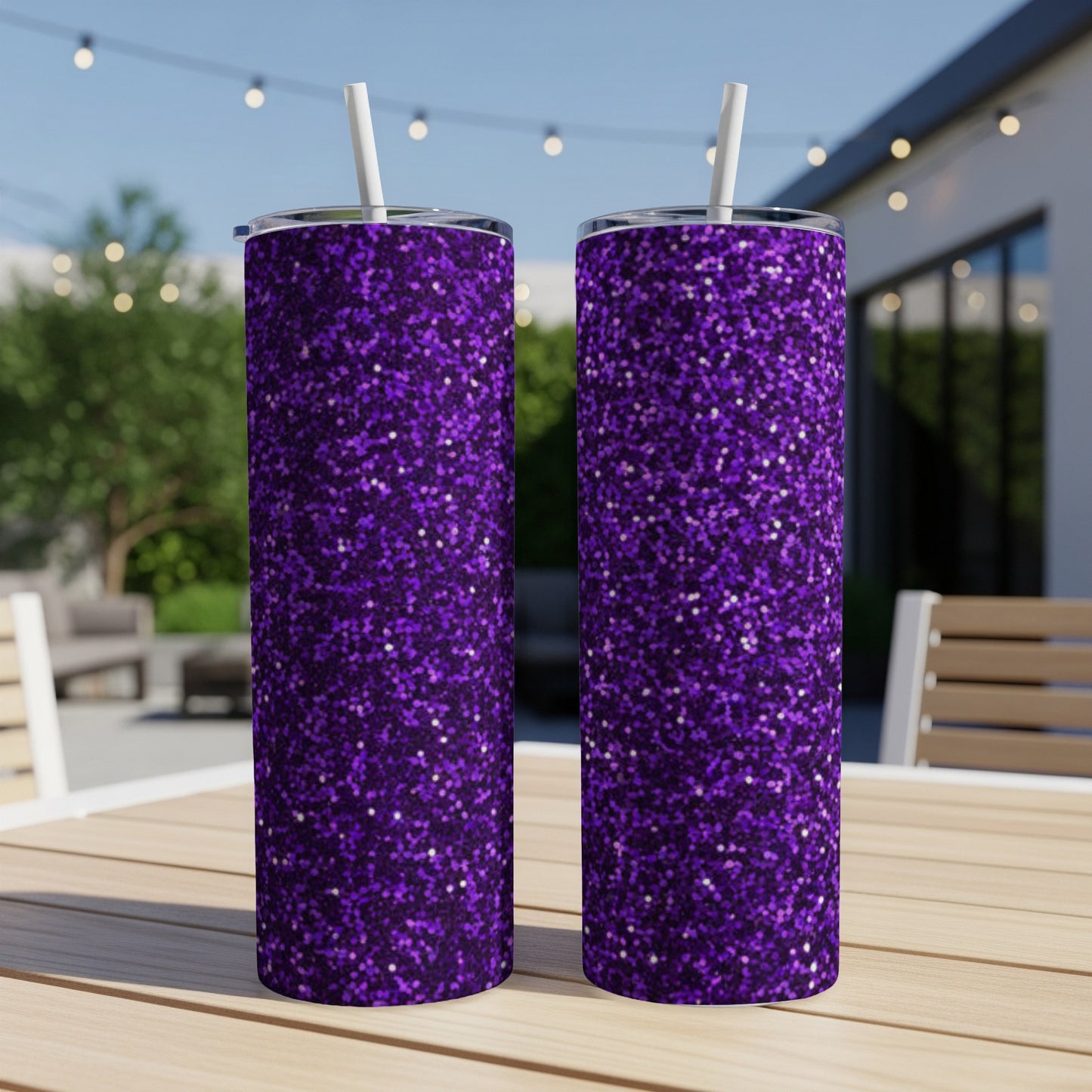 Two tall purple glitter tumblers with white straws on a wooden table.