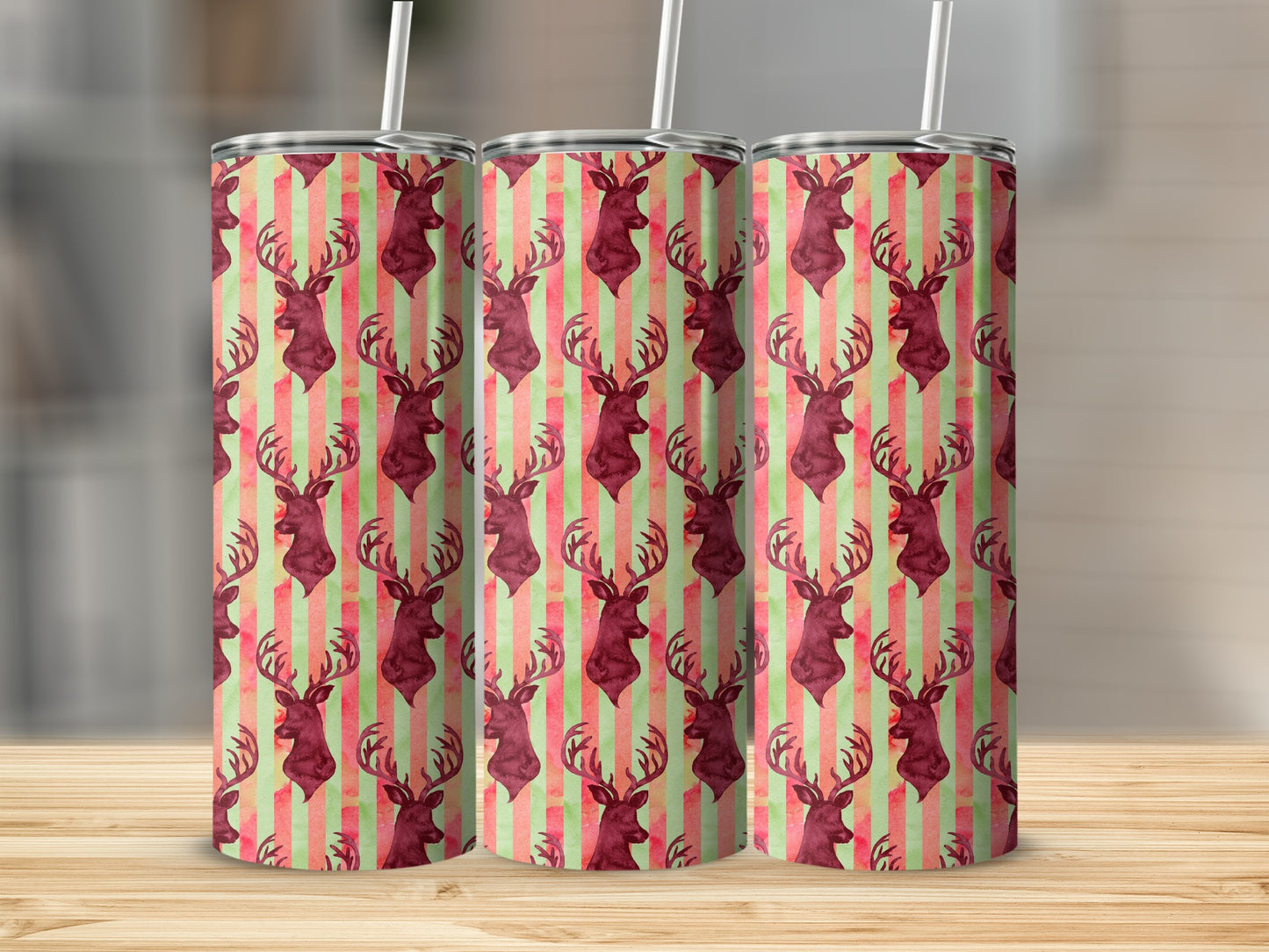Three tumblers with deer head and striped pattern on a wooden surface.
