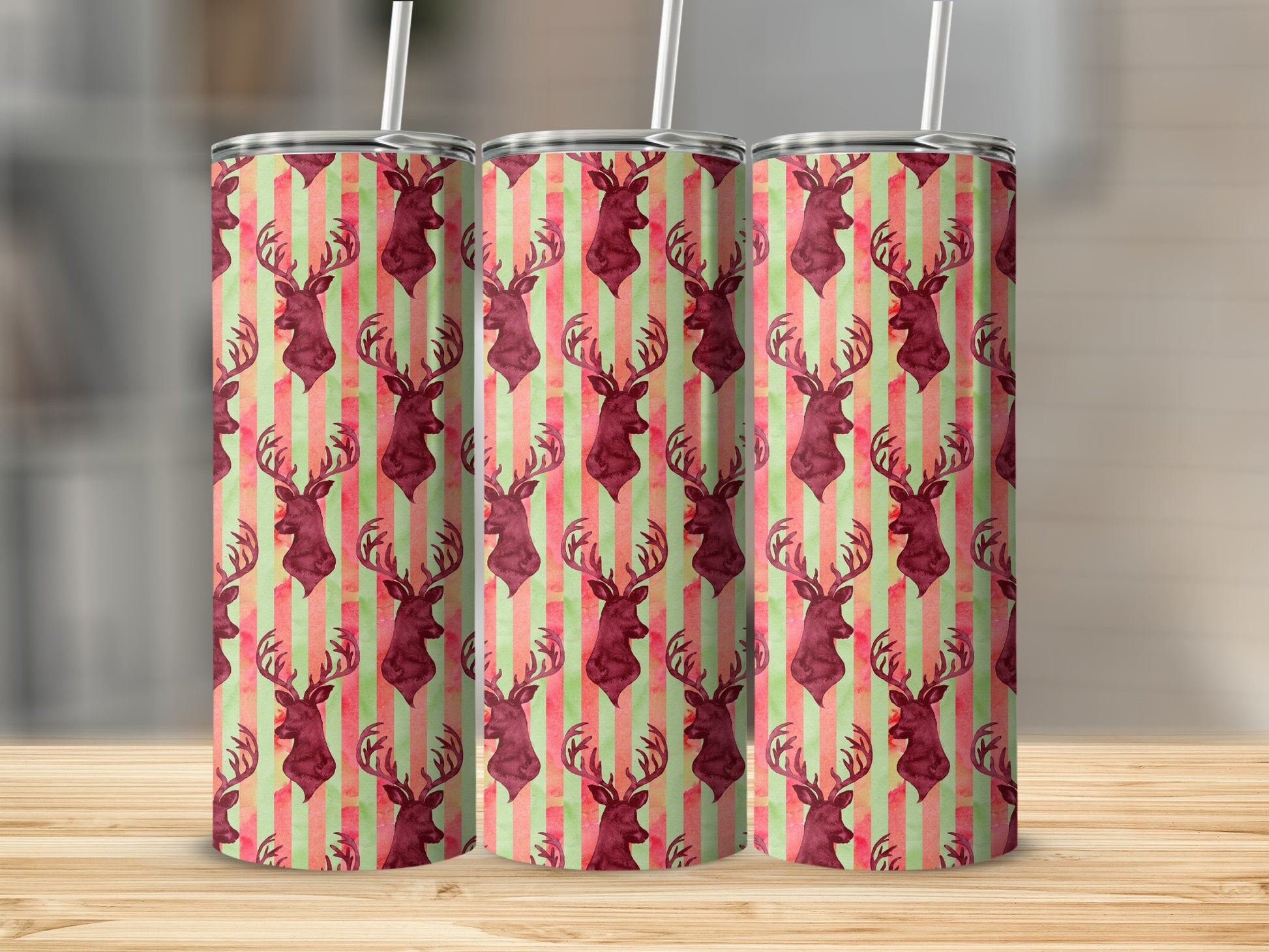 Three tumblers with deer head and striped pattern on a wooden surface.