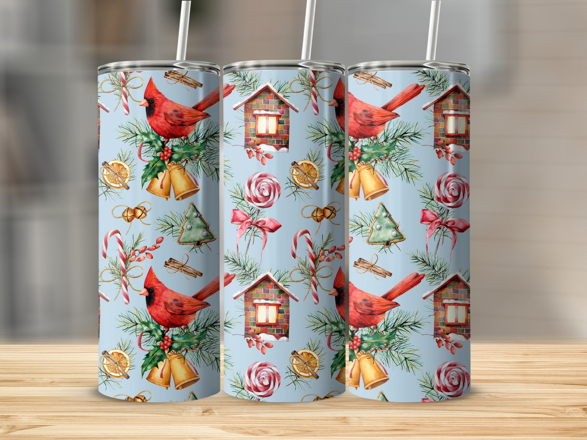 Three watercolor tumblers with cardinal, house, candy cane, and bell Christmas pattern.