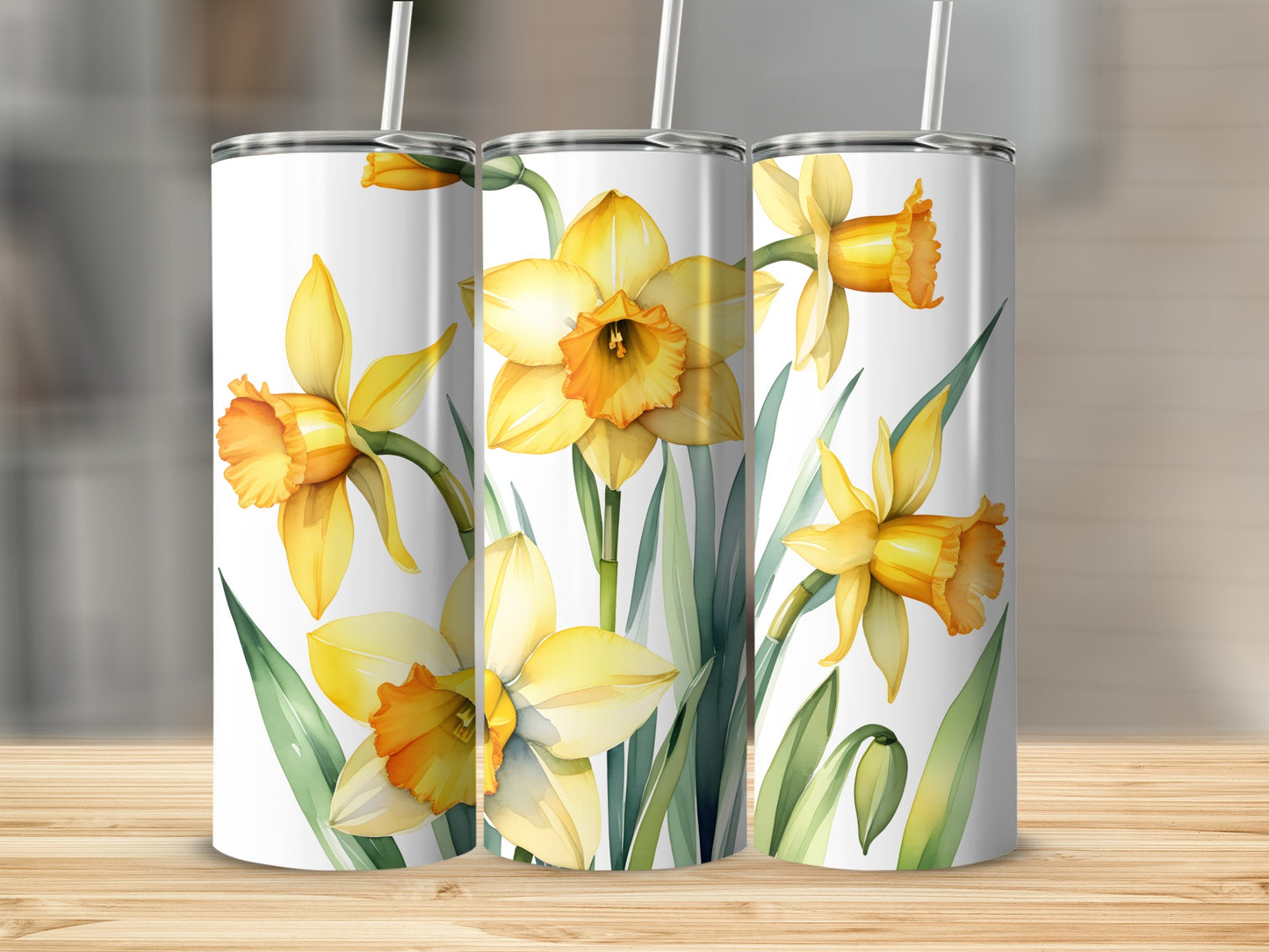 Three tumblers featuring a watercolor floral design of yellow daffodils and green leaves.