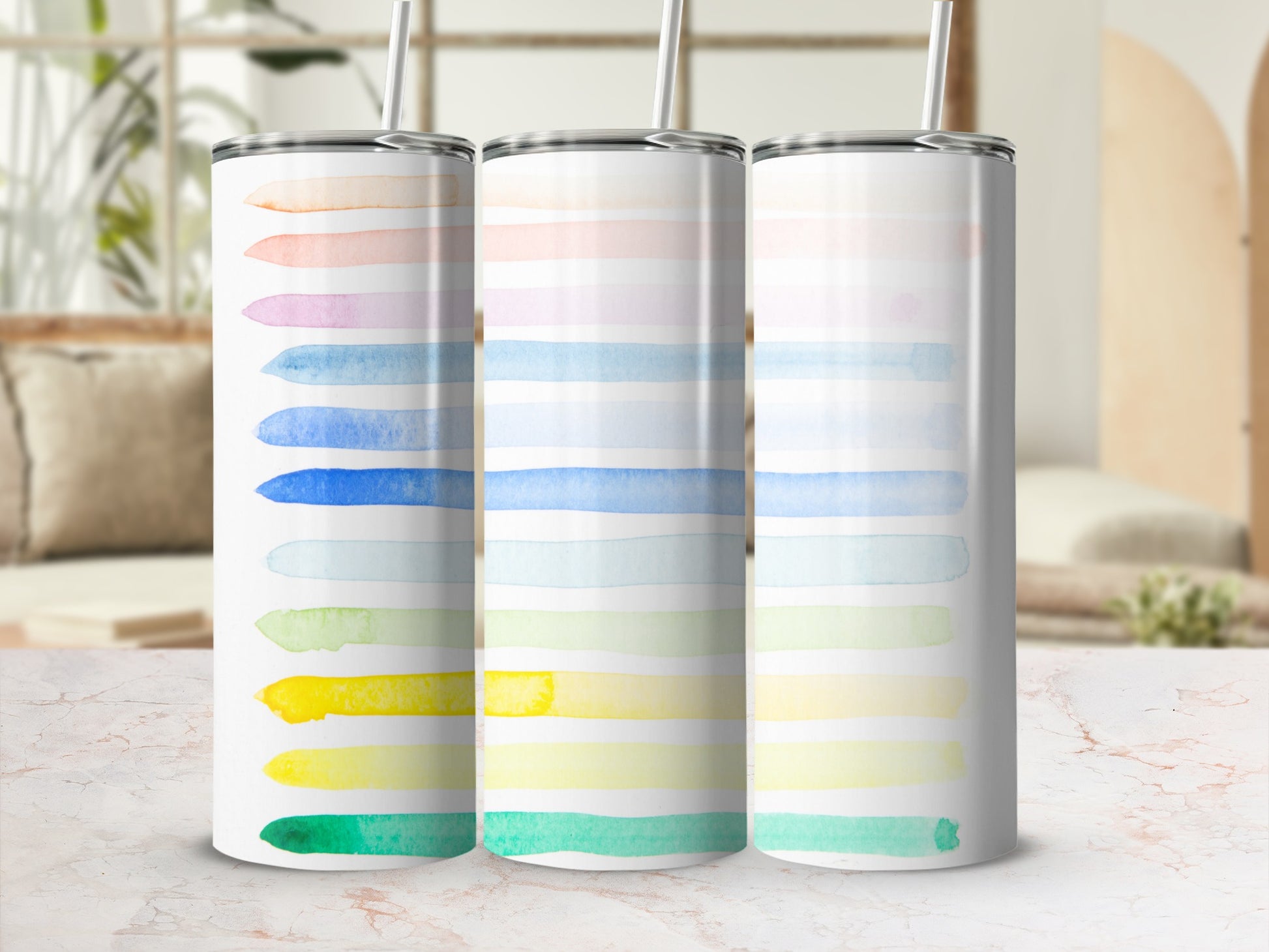 Three tumblers with colorful watercolor stripes in a gradient pattern.