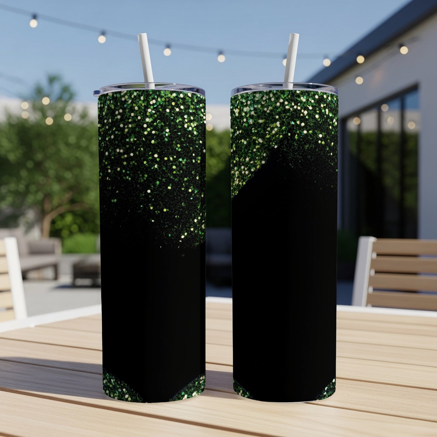 Two black tumblers with green glitter gradient design and white straws.