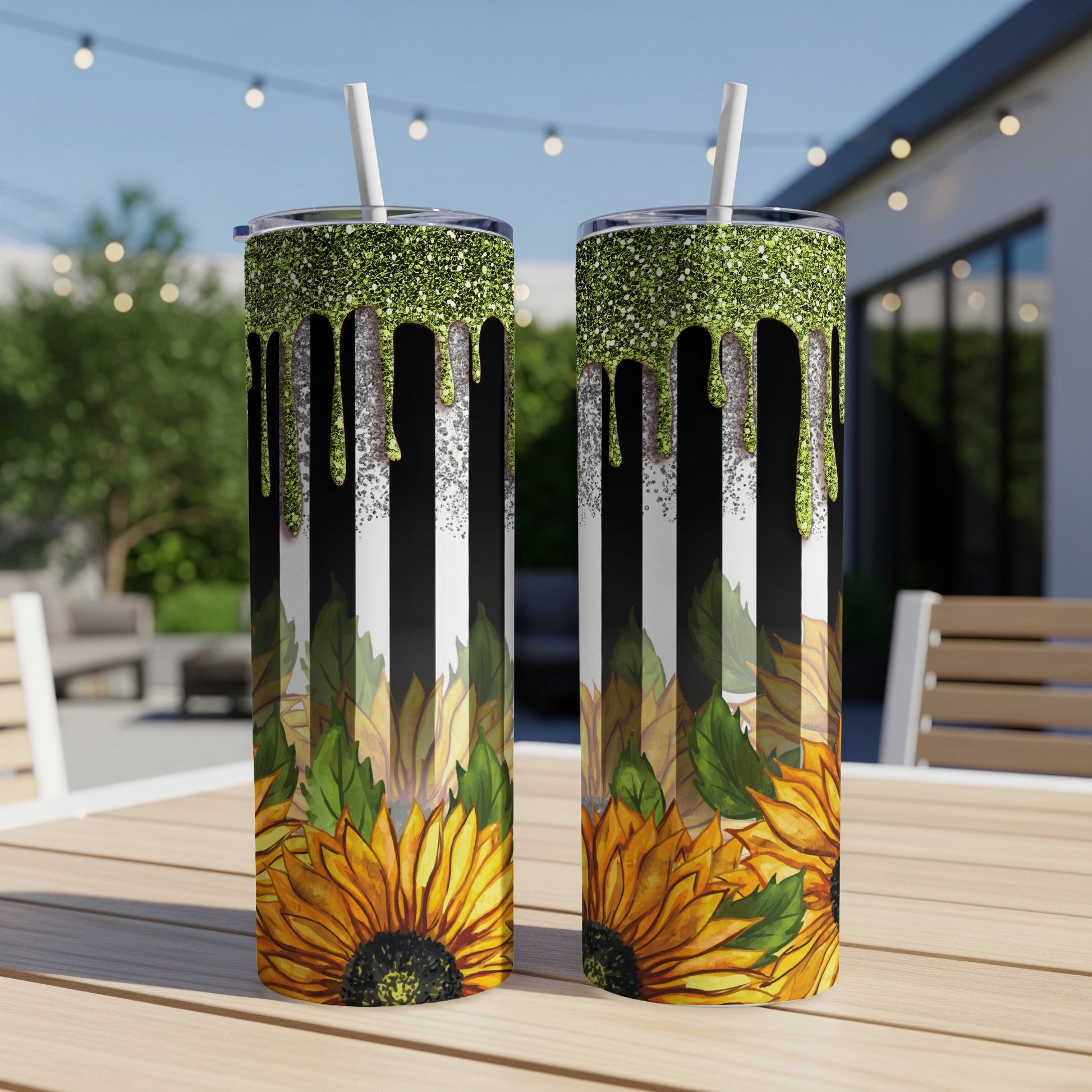 Two tumblers with sunflowers and green glitter against black and white stripes.