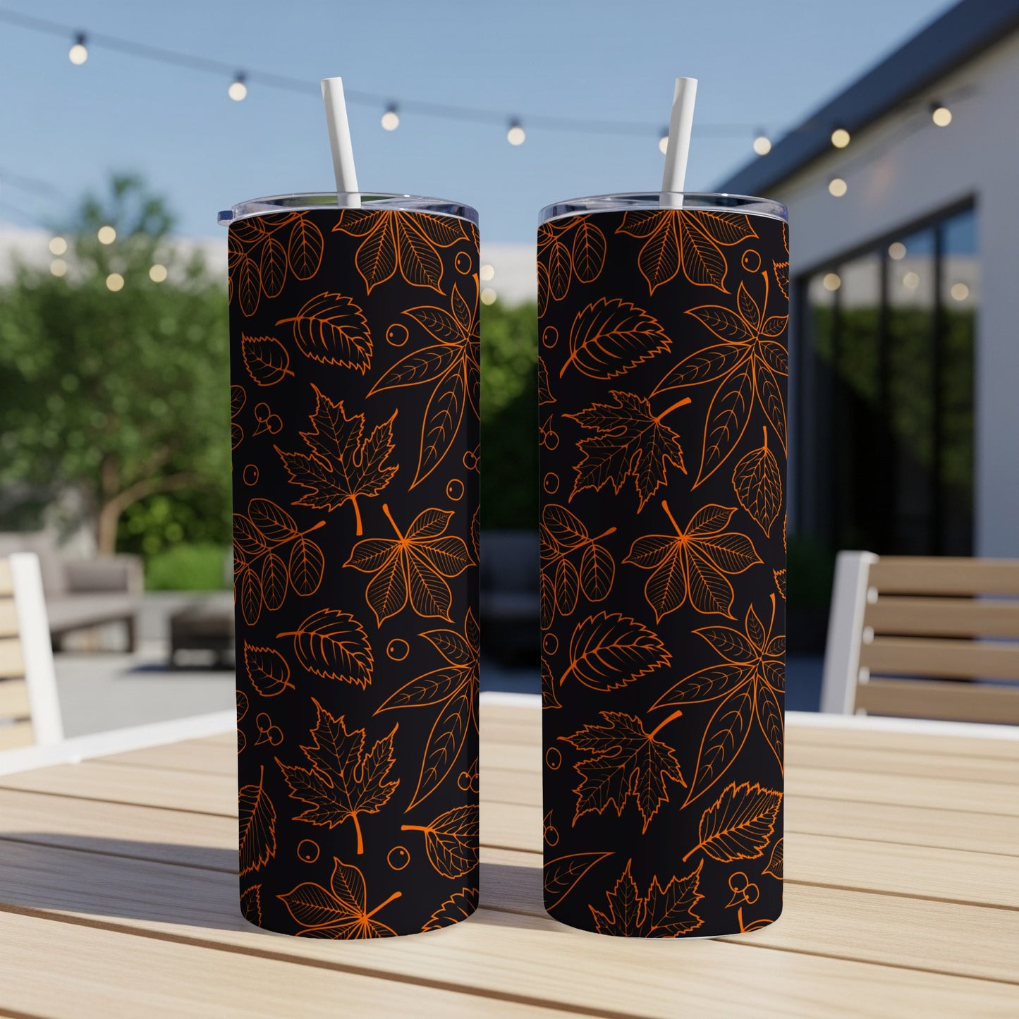 Two tall tumblers with orange leaf pattern on black background.