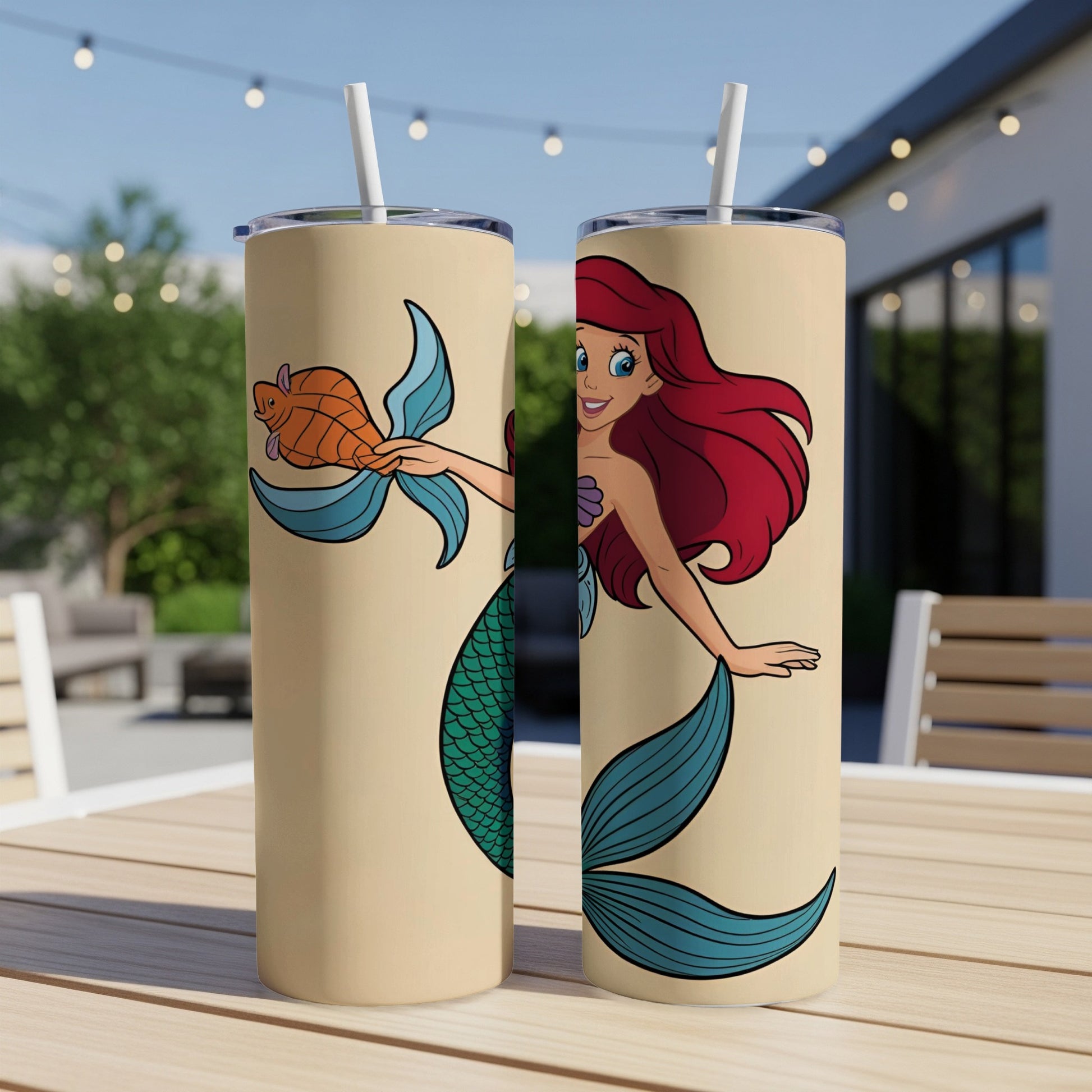 Ariel the mermaid holds a golden fish next to a teal tail.