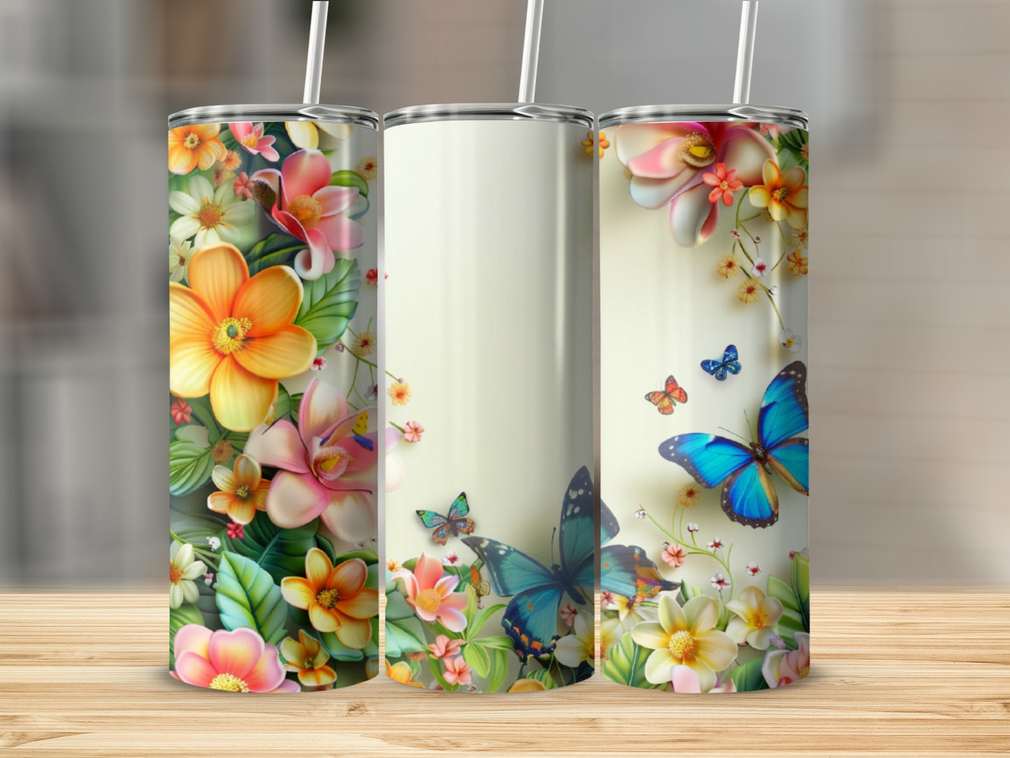 Three tumblers with floral and butterfly designs on a wooden surface.