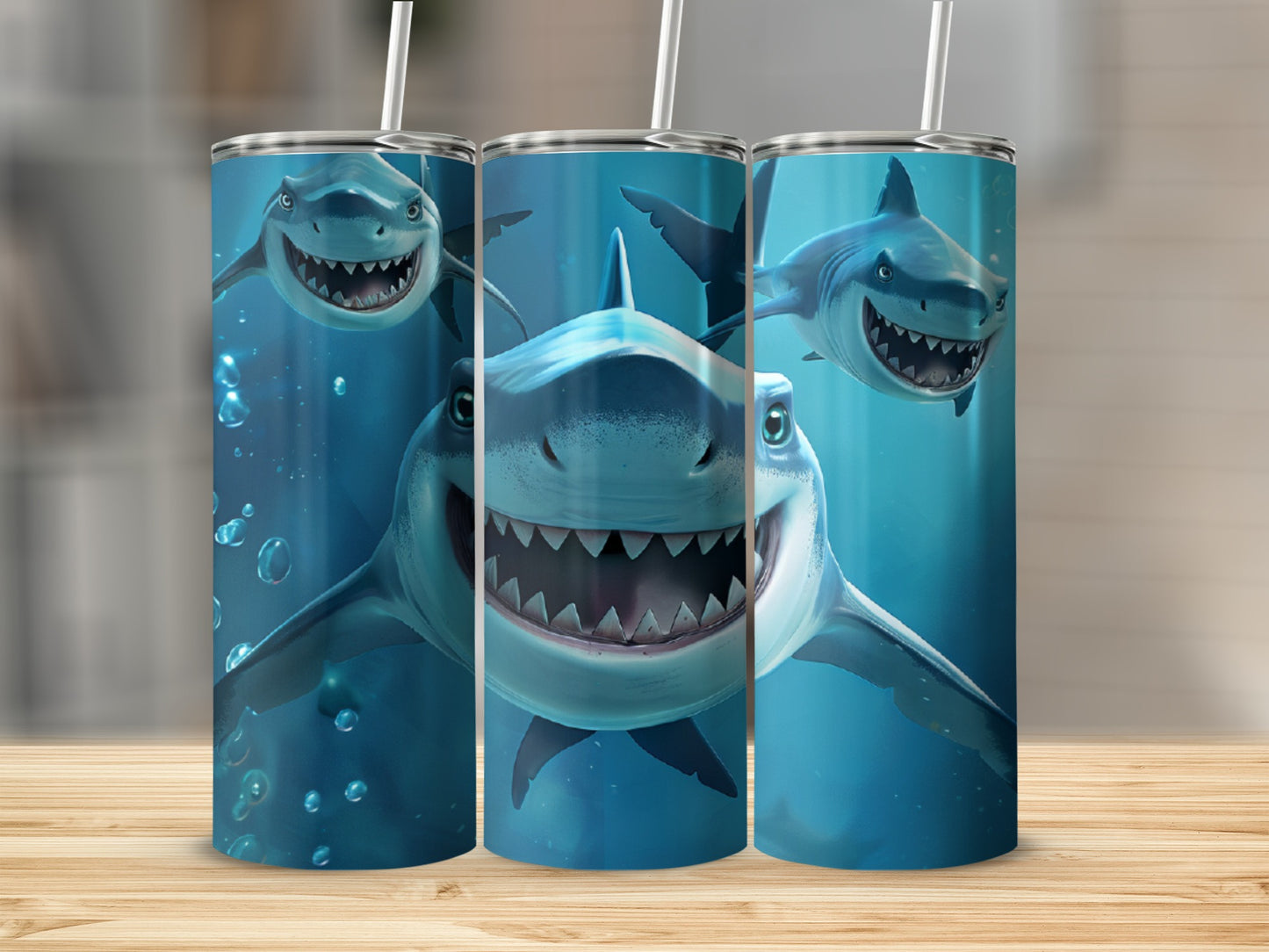 Three tumblers with cartoon sharks on a wooden surface.