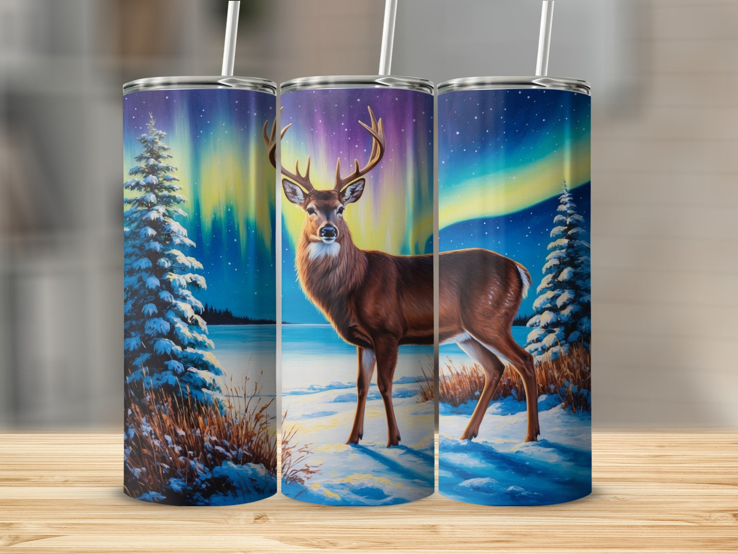 Deer in snowy landscape with aurora borealis on three tumblers.