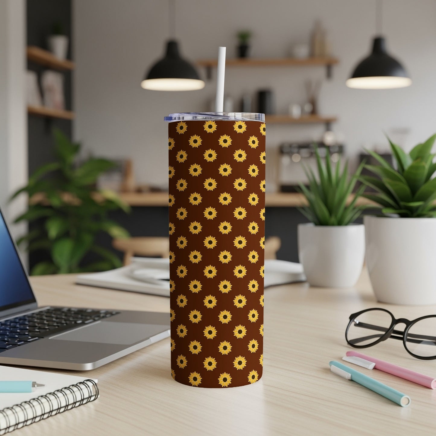 Brown tumbler with repeating yellow sunflower pattern and white lid.