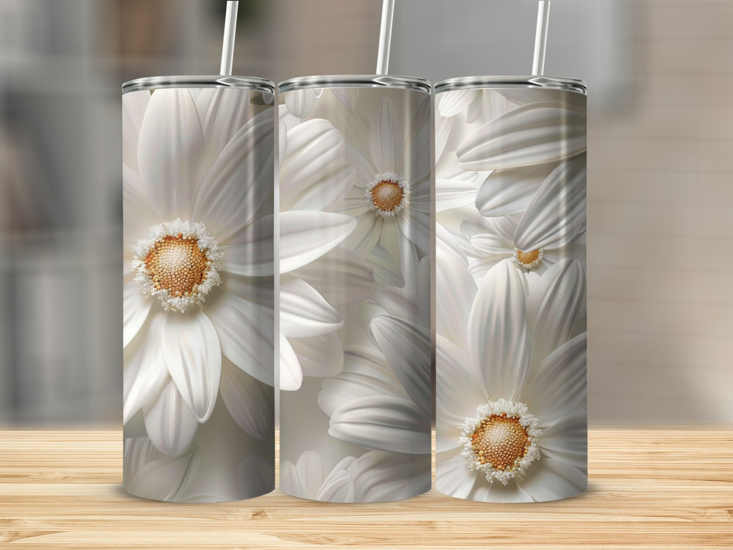 Three white daisy floral tumblers with straws on a wooden surface.