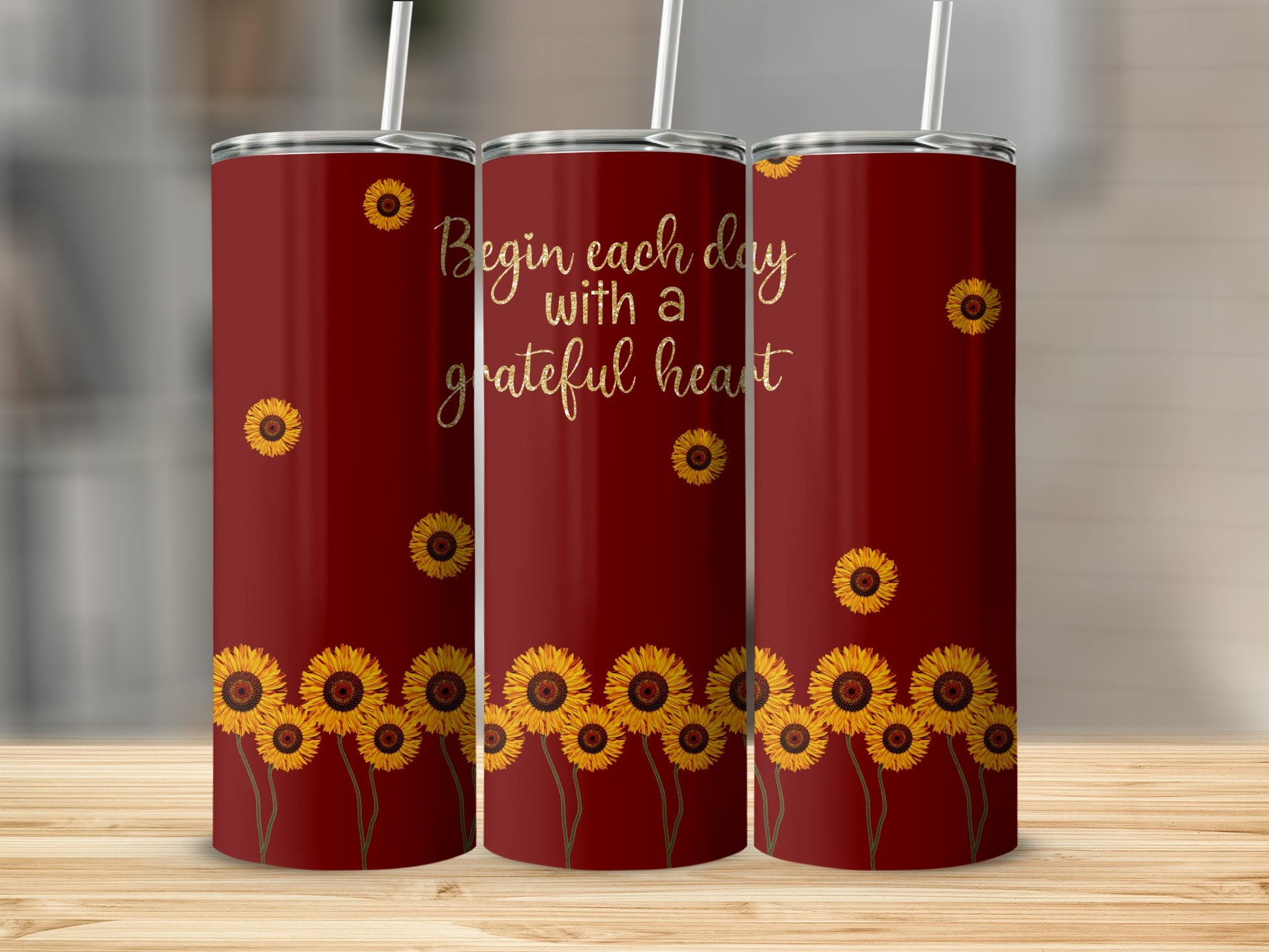 Maroon tumbler with sunflowers and text "Begin each day with a grateful heart".
