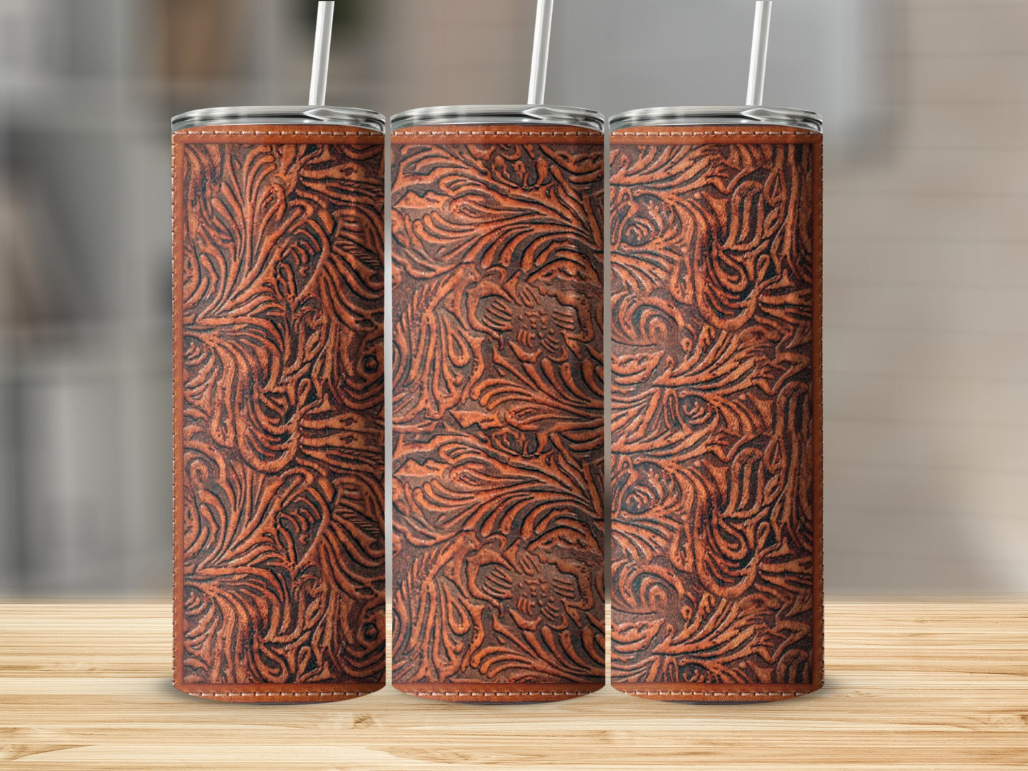Three brown leather-textured tumblers with embossed floral pattern and white straws.