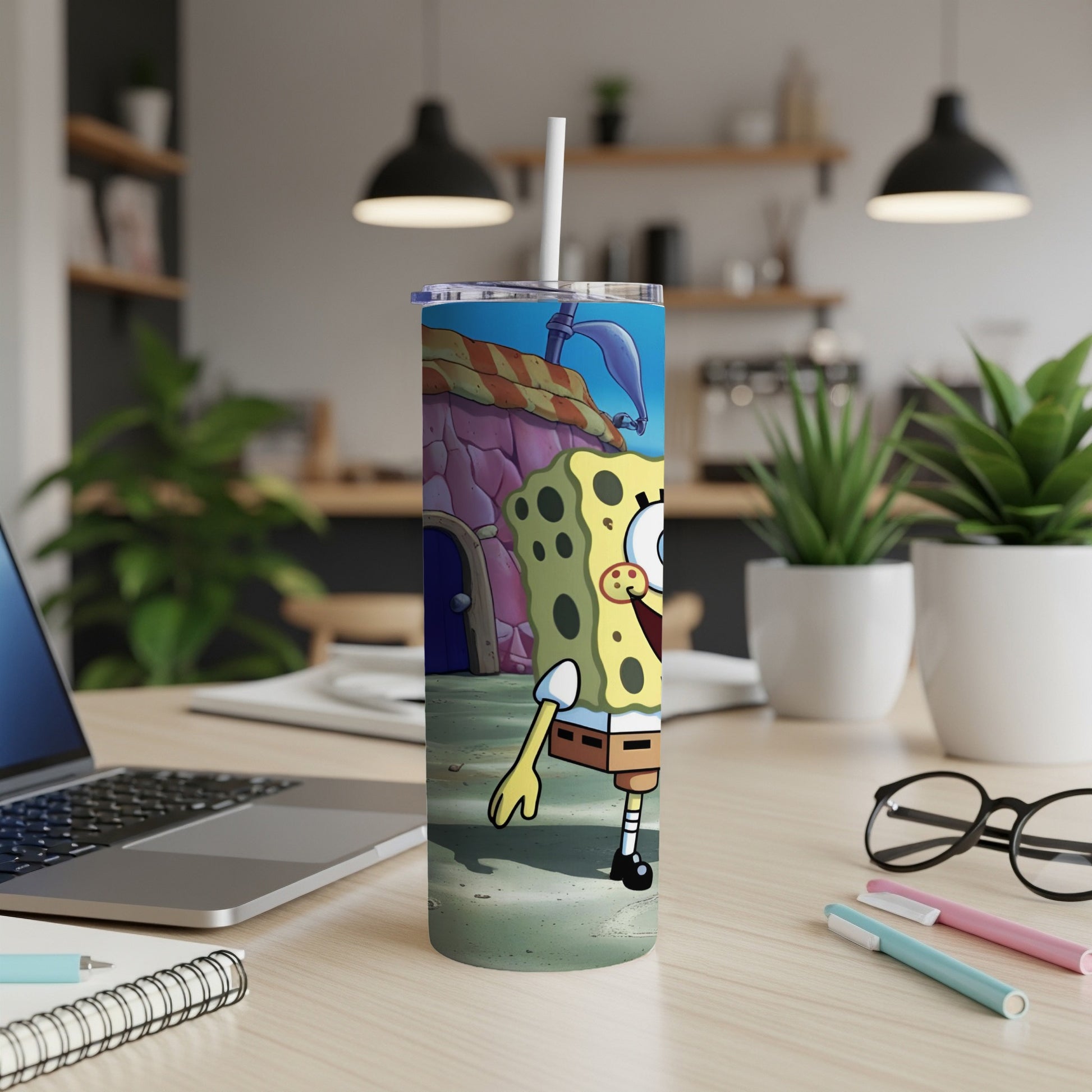 SpongeBob SquarePants character on a tumbler with a straw, on a desk.