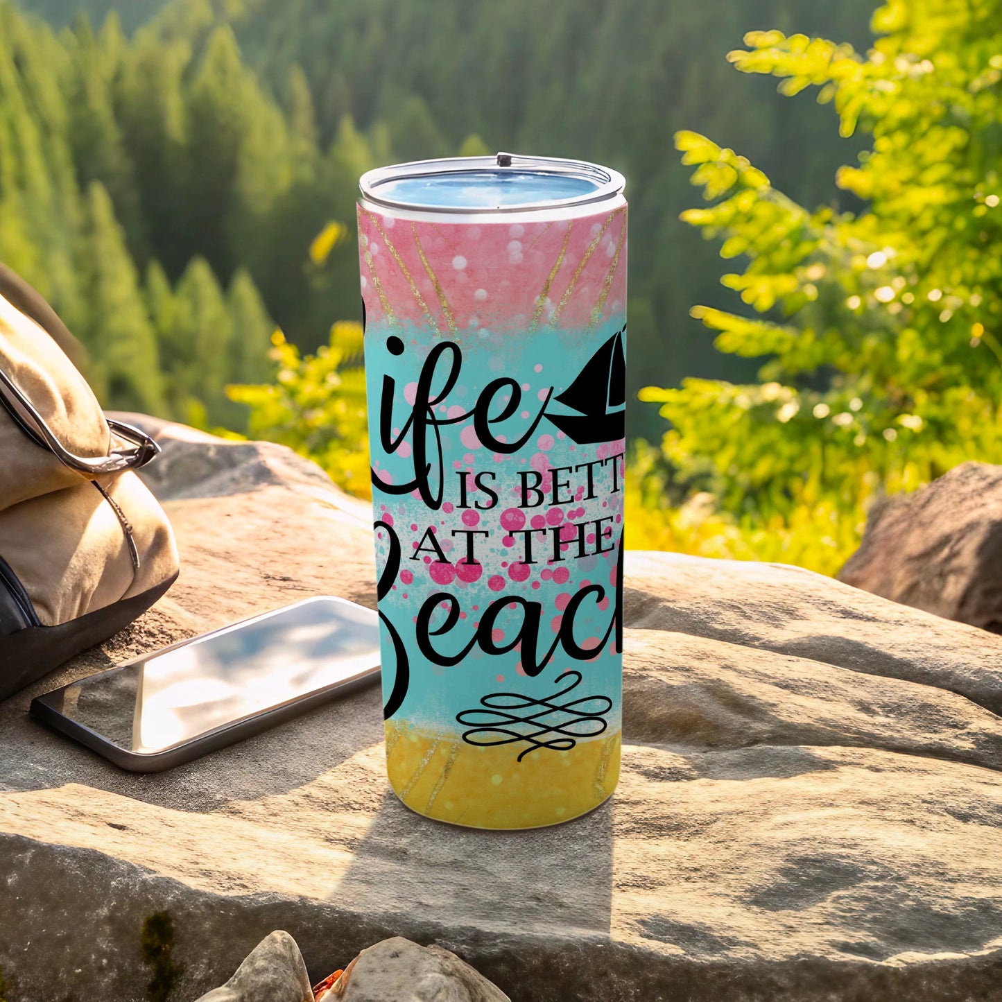 Tumbler with "life is better at the beach" text and sailboat graphic.