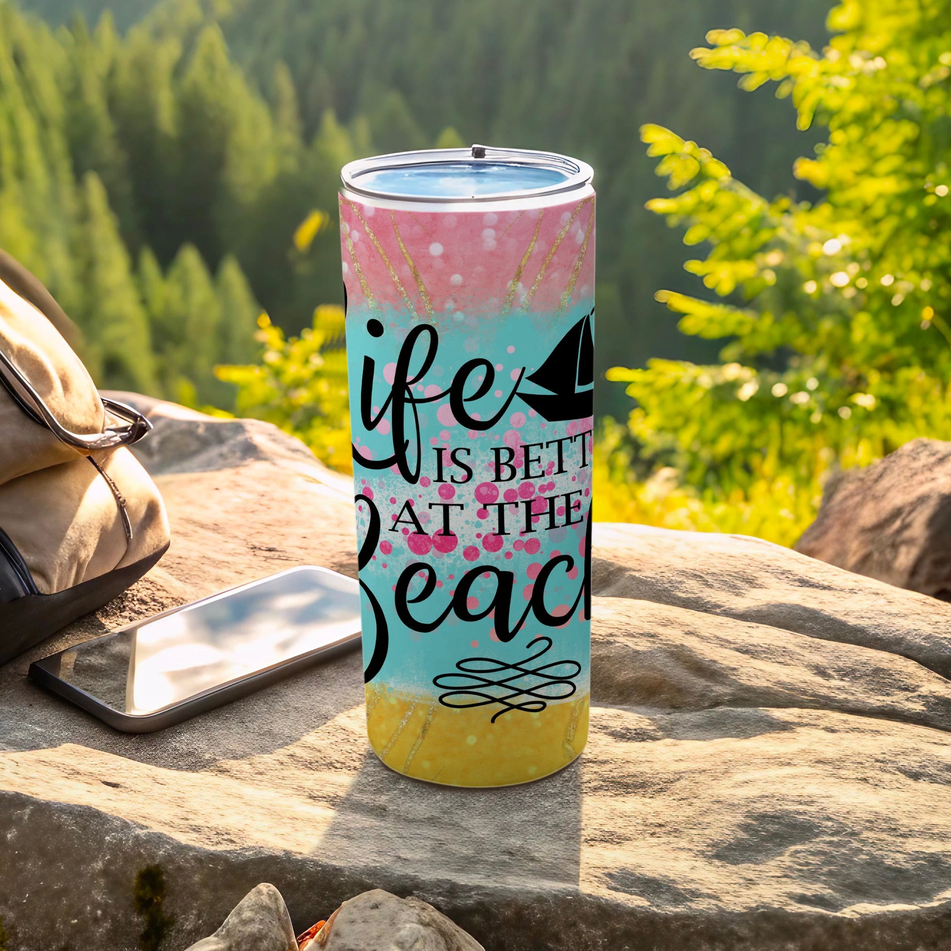 Tumbler with "life is better at the beach" text and sailboat graphic.