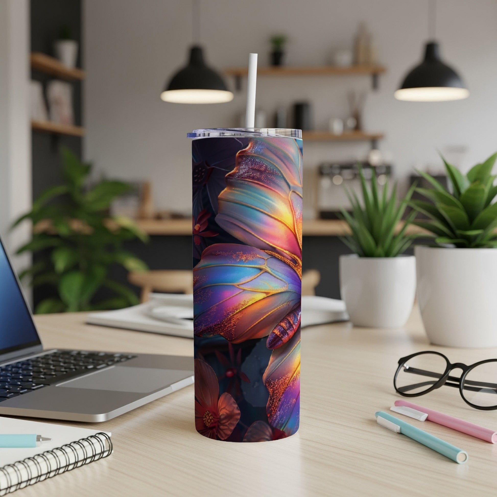 Rainbow butterfly tumbler on a desk with a laptop and pens.