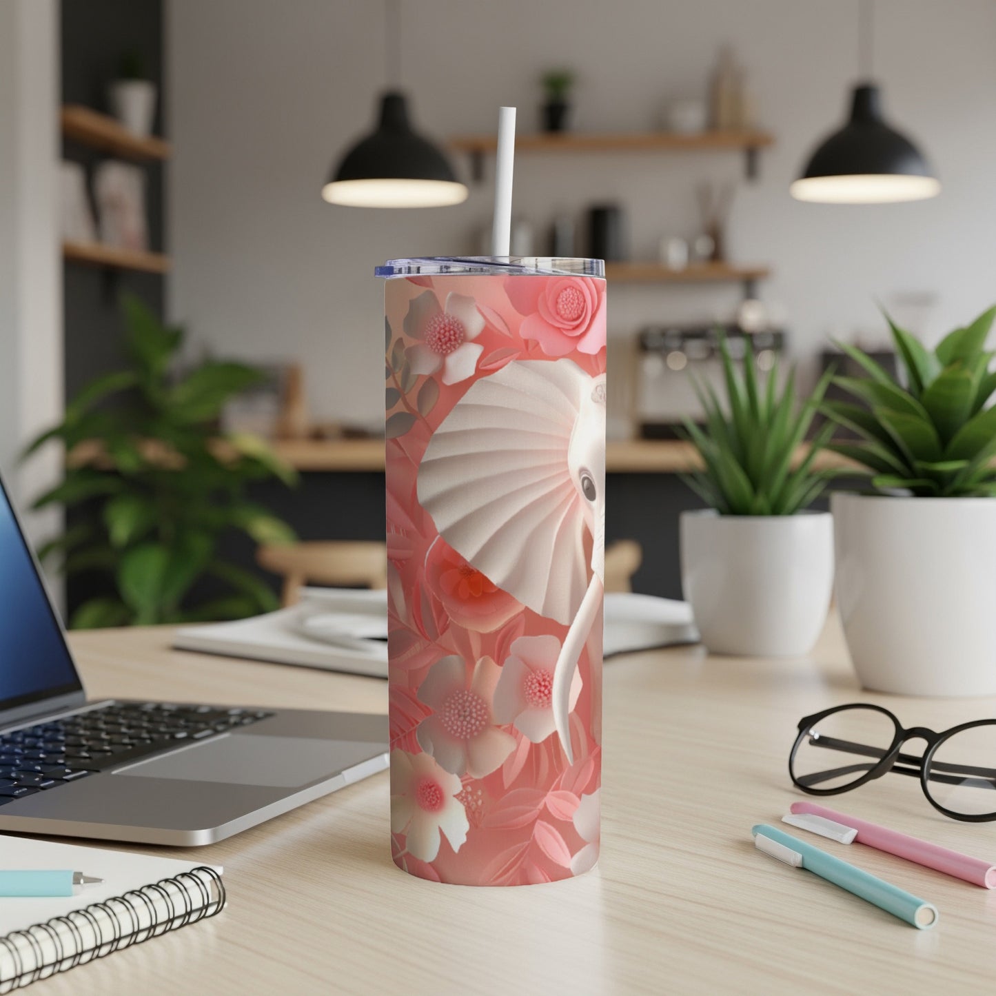 Pink floral elephant tumbler with straw on a desk.