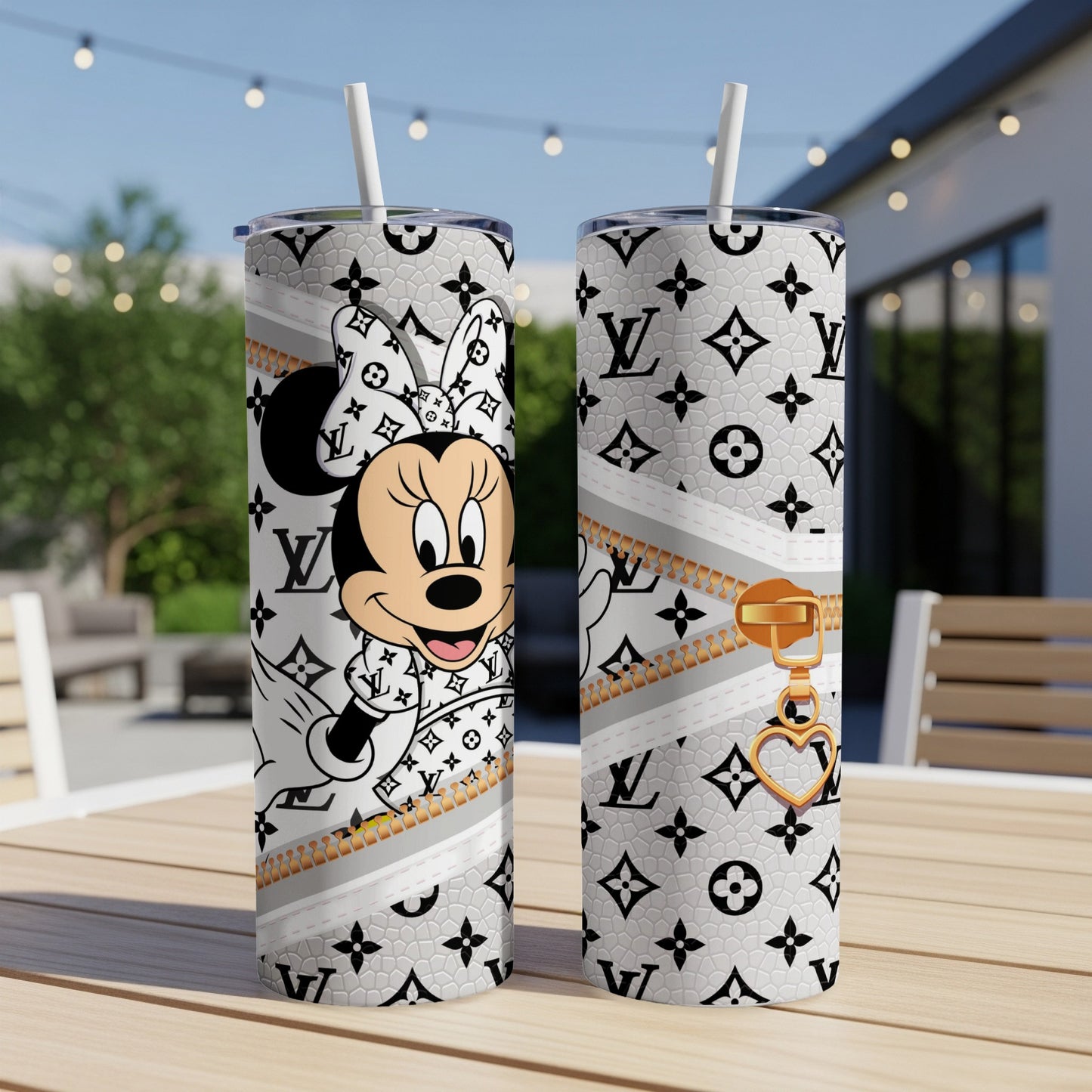 Minnie Mouse and LV pattern on two white tumblers with straws on a table.