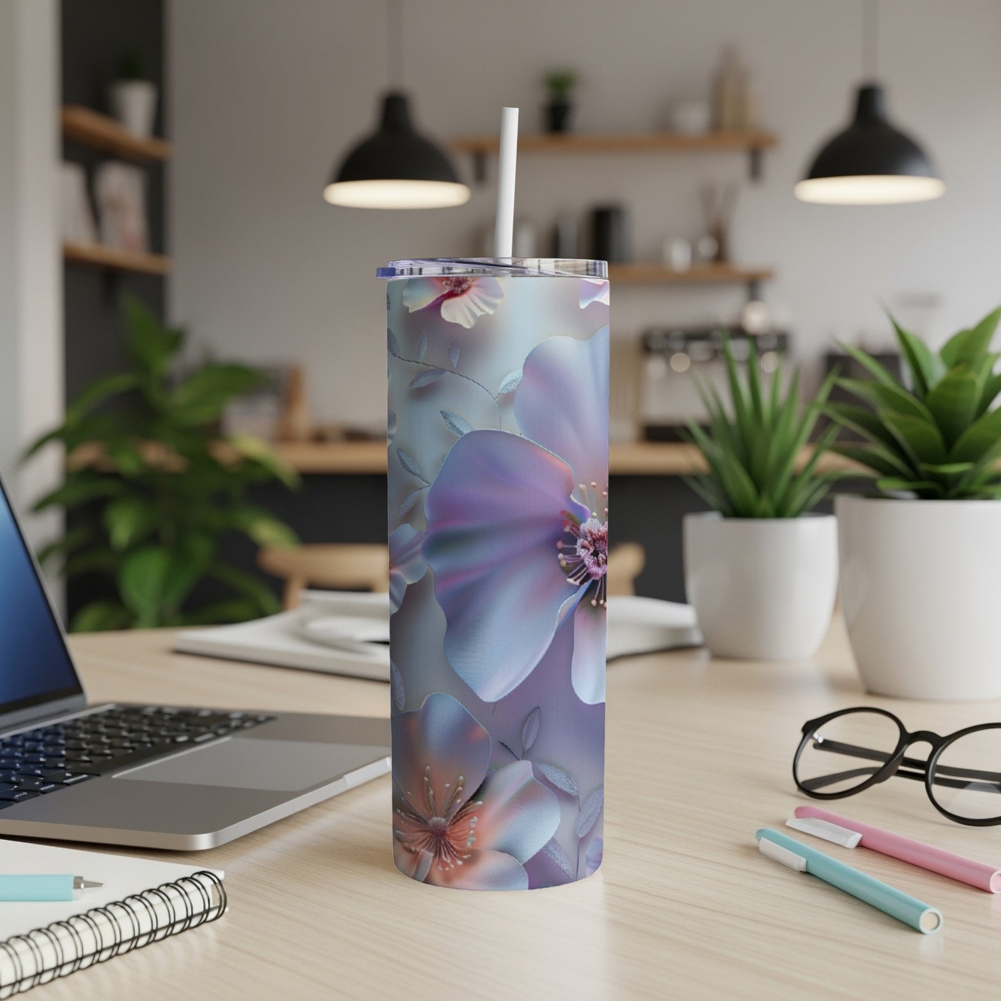 Purple floral tumbler with straw on a desk with a laptop.