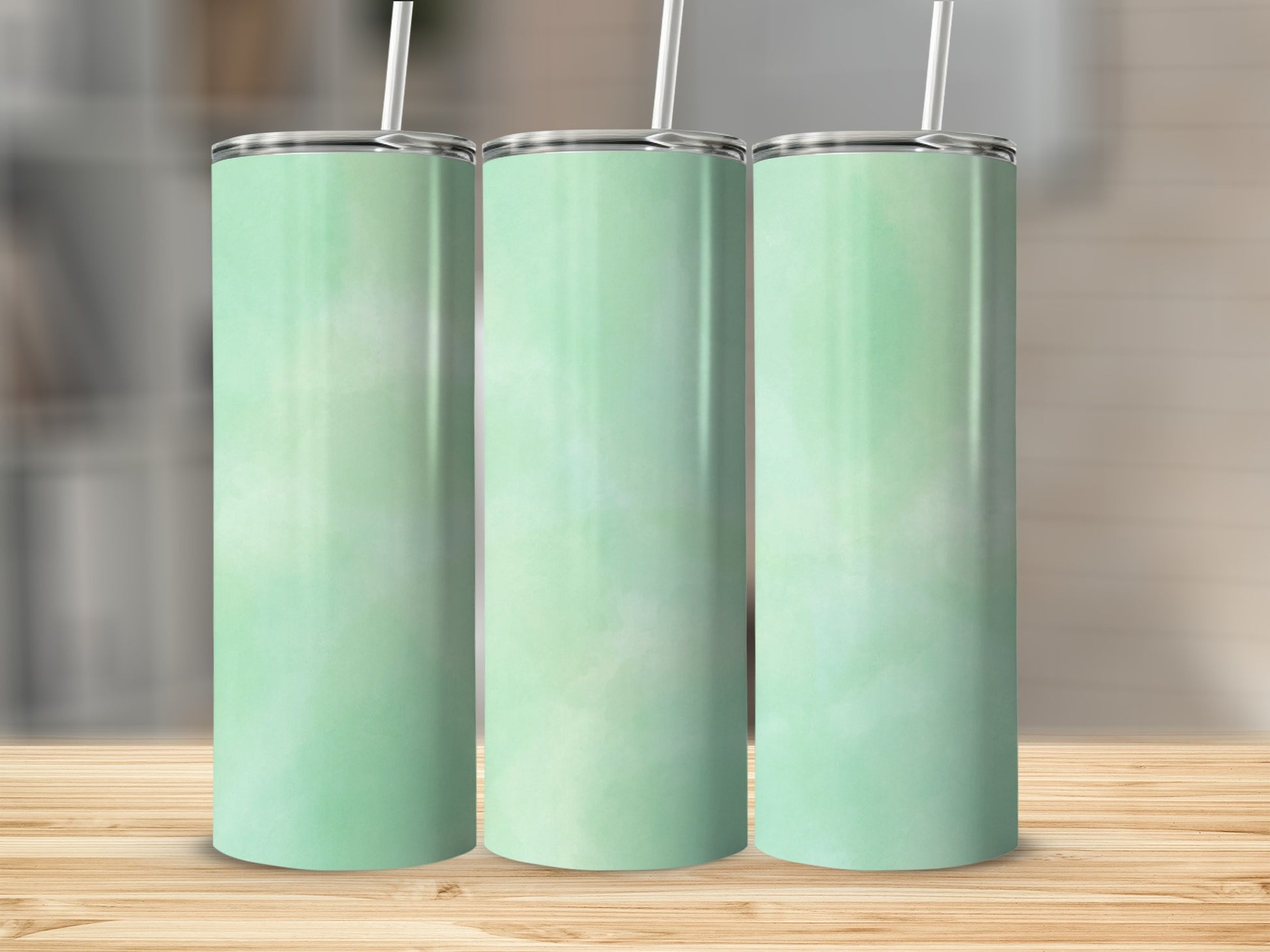 Three mint green tumblers with white straws on a wooden surface.